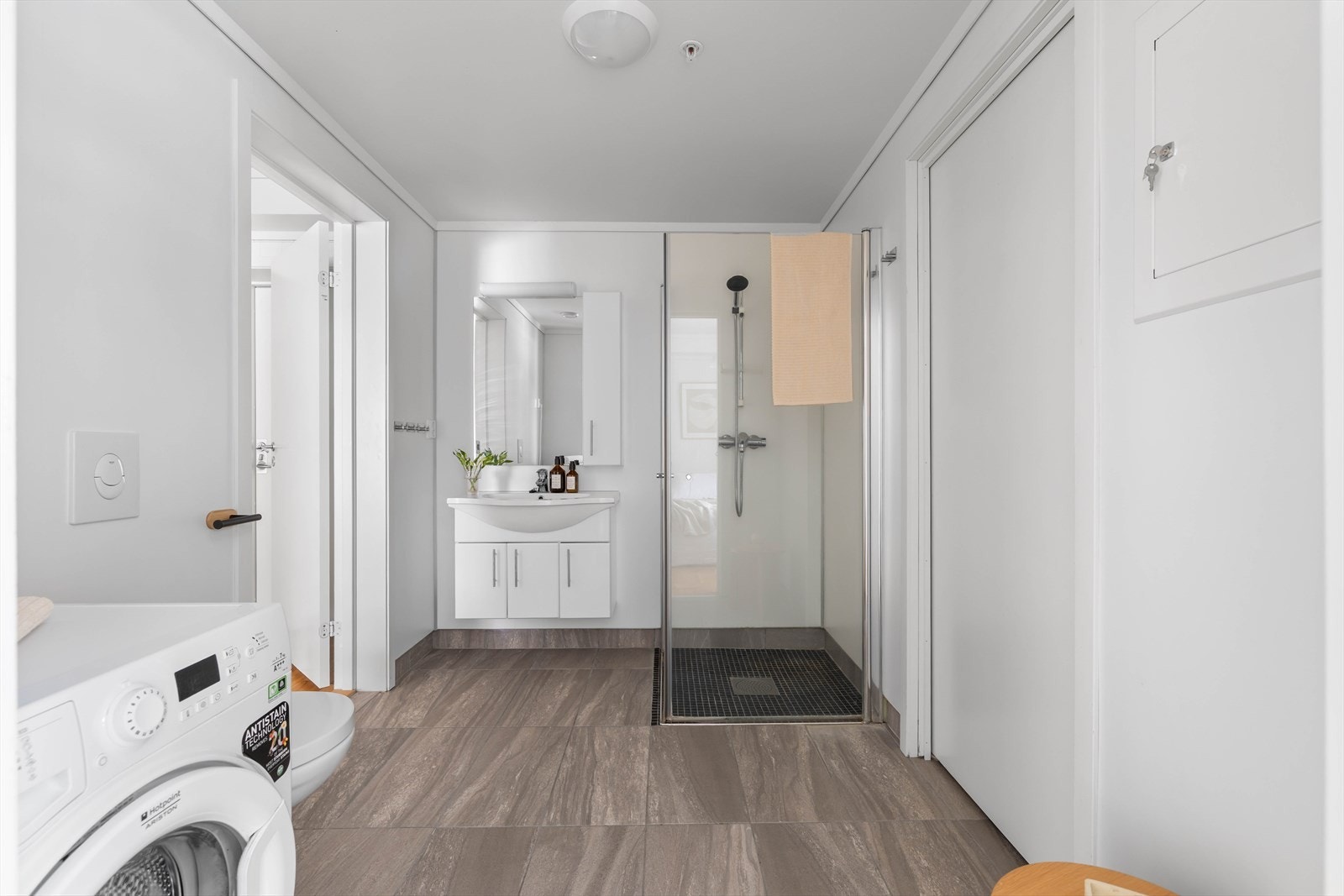 Lekkert baderom med gulvvarme på flislagt gulv og baderomsplater på veggene Galleribilde