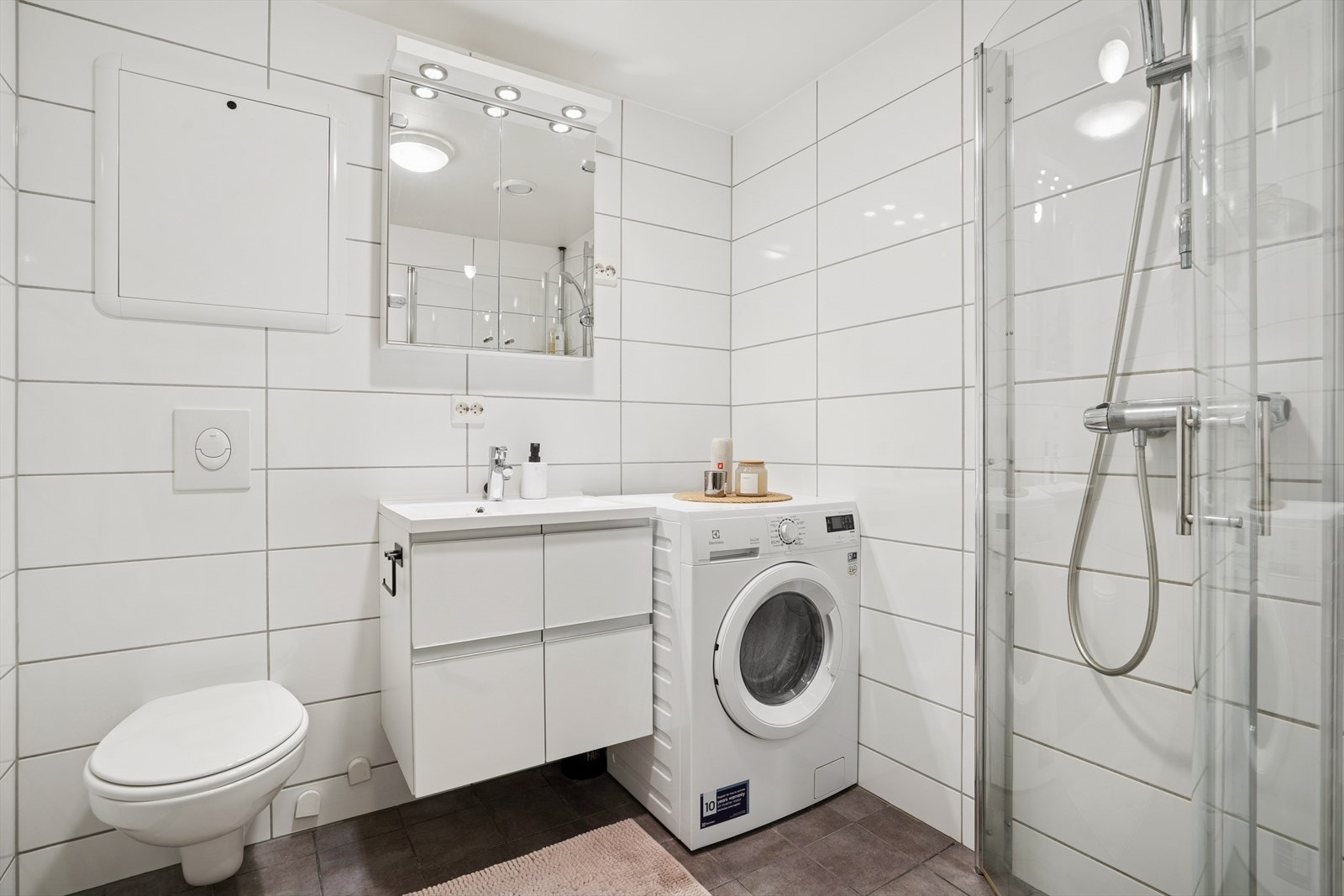 Badet er innredet med toalett, servant og dusj, samt opplegg for vaskemaskin. Galleribilde