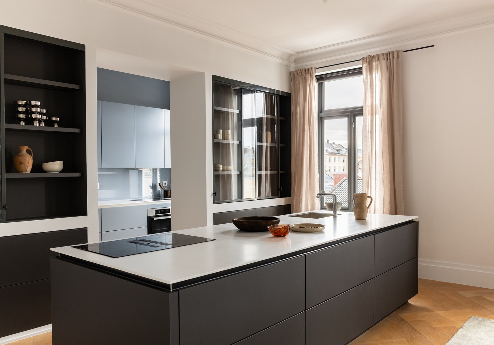 Kjøkkenøyen gir ekstra benkeplass og skaper en effektiv arbeidssone med god oppbevaring i integrerte skap. Galleribilde