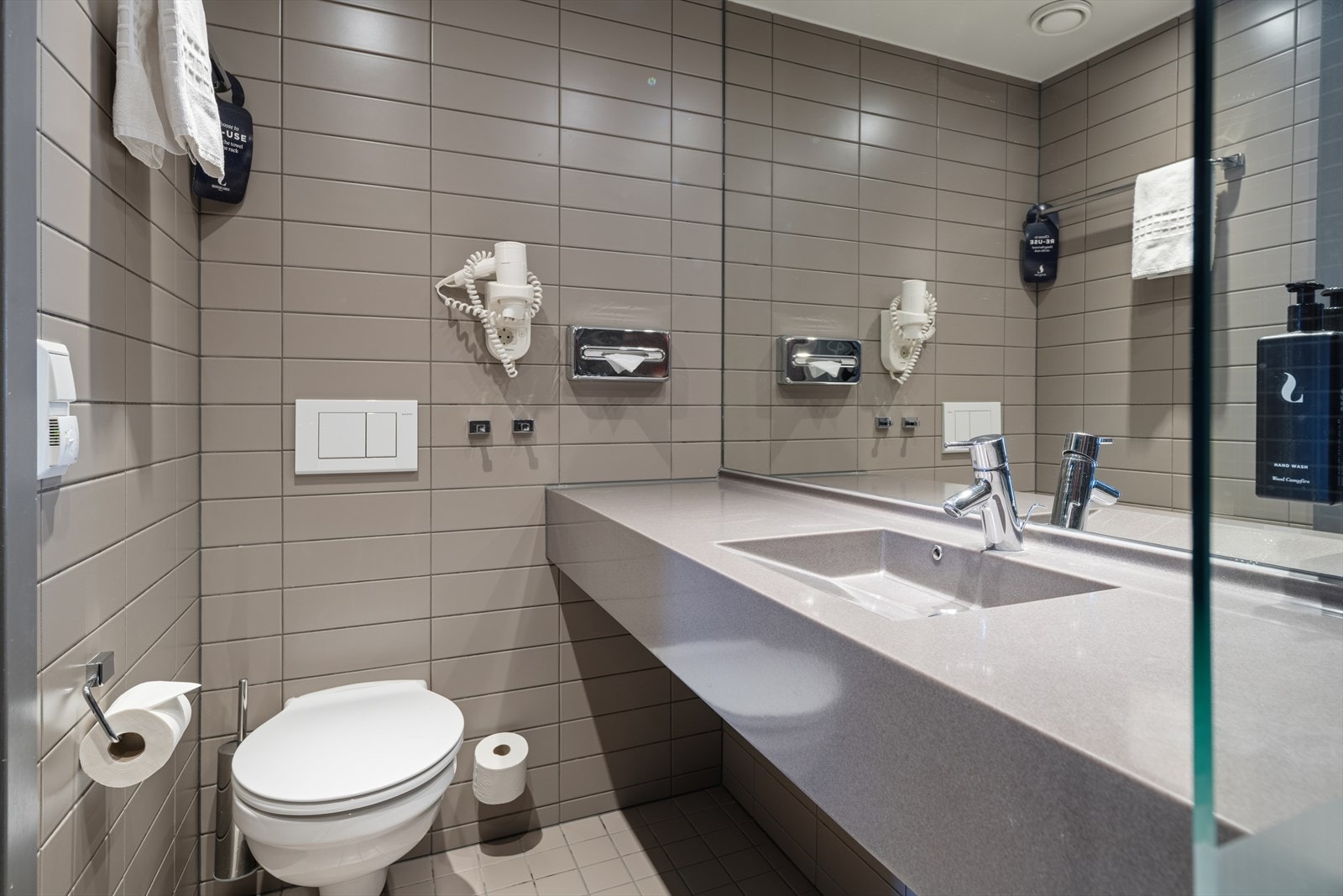 Innbydende og romslig baderom med fliser på gulv og vegg. Galleribilde