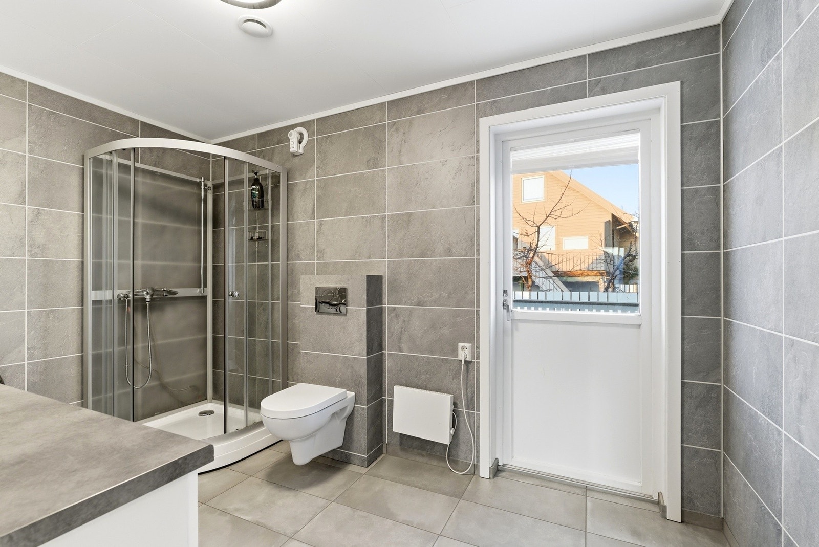 Fra rommet har man direkte adkomst til terrasse og hageområdet, hvor man kan nyte solen helt fram til ca kl. 21.30 Galleribilde