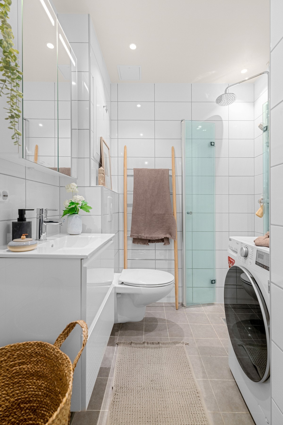 Leiligheten har et lyst og moderne flislagt baderom som ble pusset opp i regi av sameiet i 2020. Galleribilde