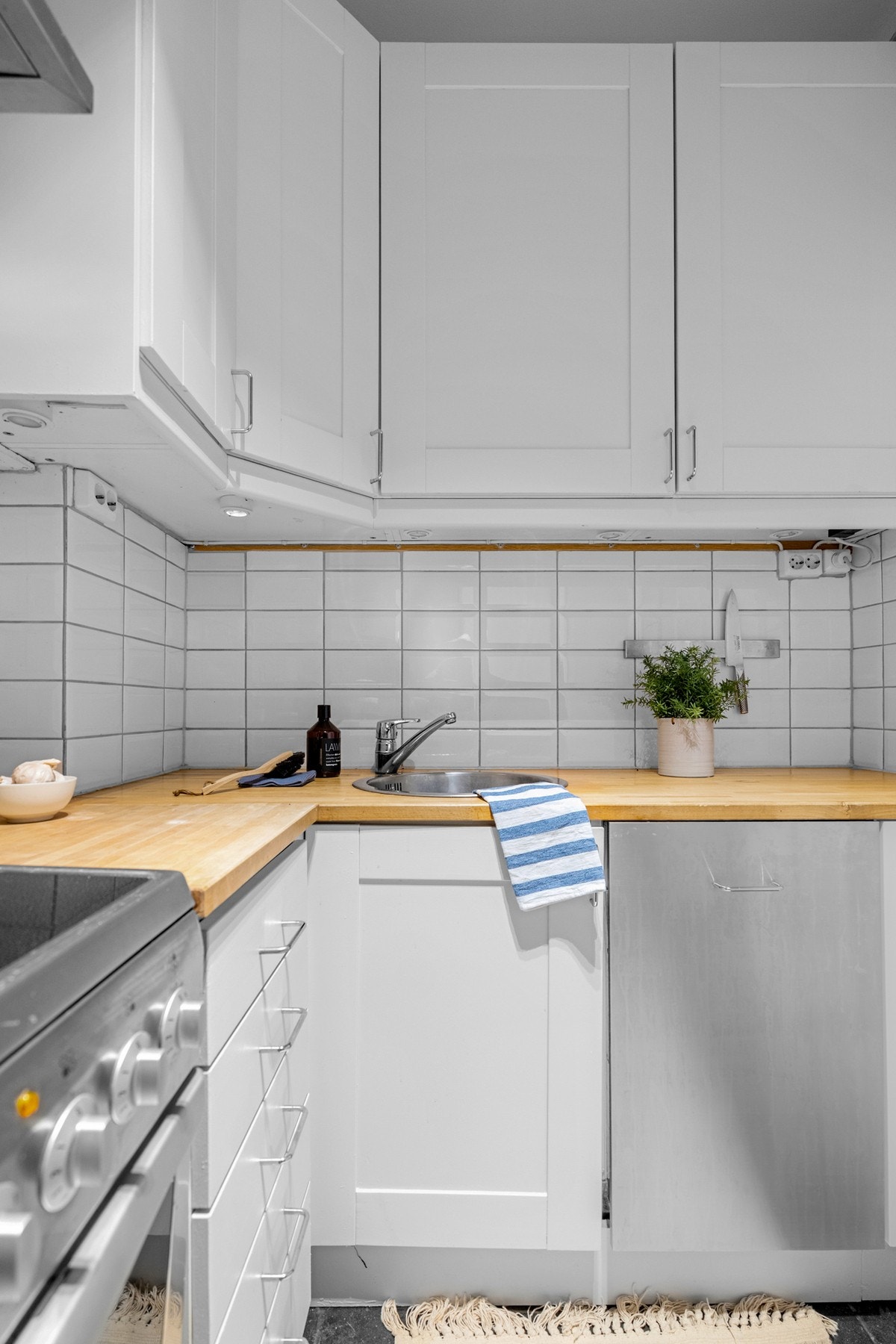 Praktisk med lyse fliser i benkeryggen og belysning under overskapene. Galleribilde