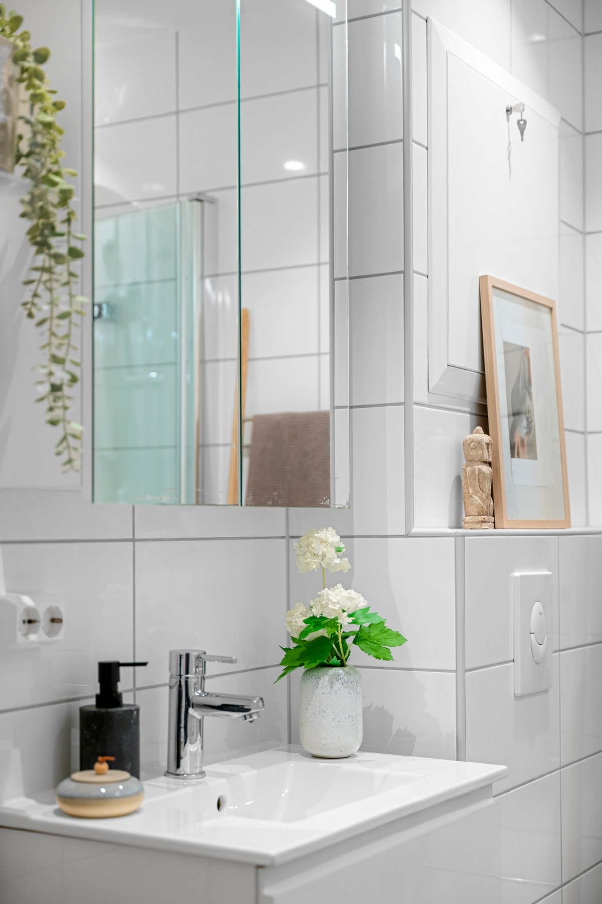 Moderne baderomsinnredning med skuffer og heldekkende servant, speilskap med integrert belysning over. Galleribilde