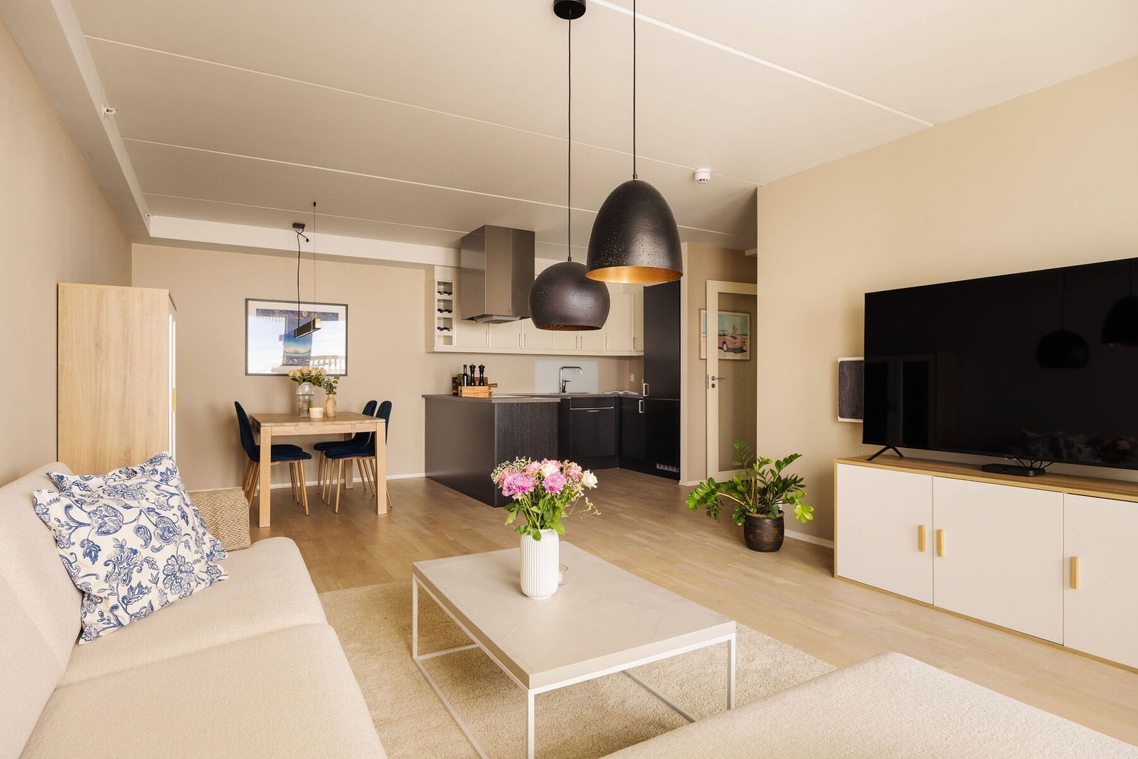 Parkettgulvet tilfører rommet et varmt og helhetlig preg, mens de store vindusflatene slipper inn rikelig med dagslys og skaper en behagelig og luftig atmosfære gjennom hele dagen. Galleribilde