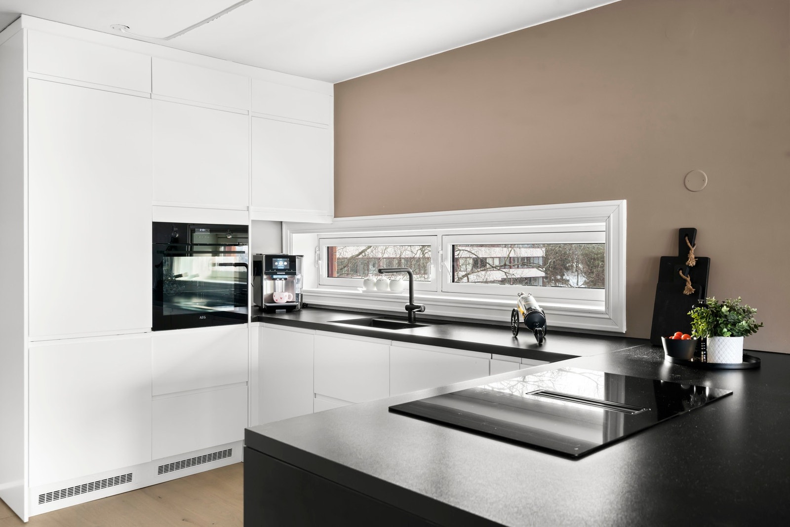 Innredningen har glatte, fabrikklakkerte fronter som gir et stilrent preg, kombinert med laminat benkeplate og planlimt kum i kompositt/plast for en praktisk og funksjonell arbeidssone. Galleribilde