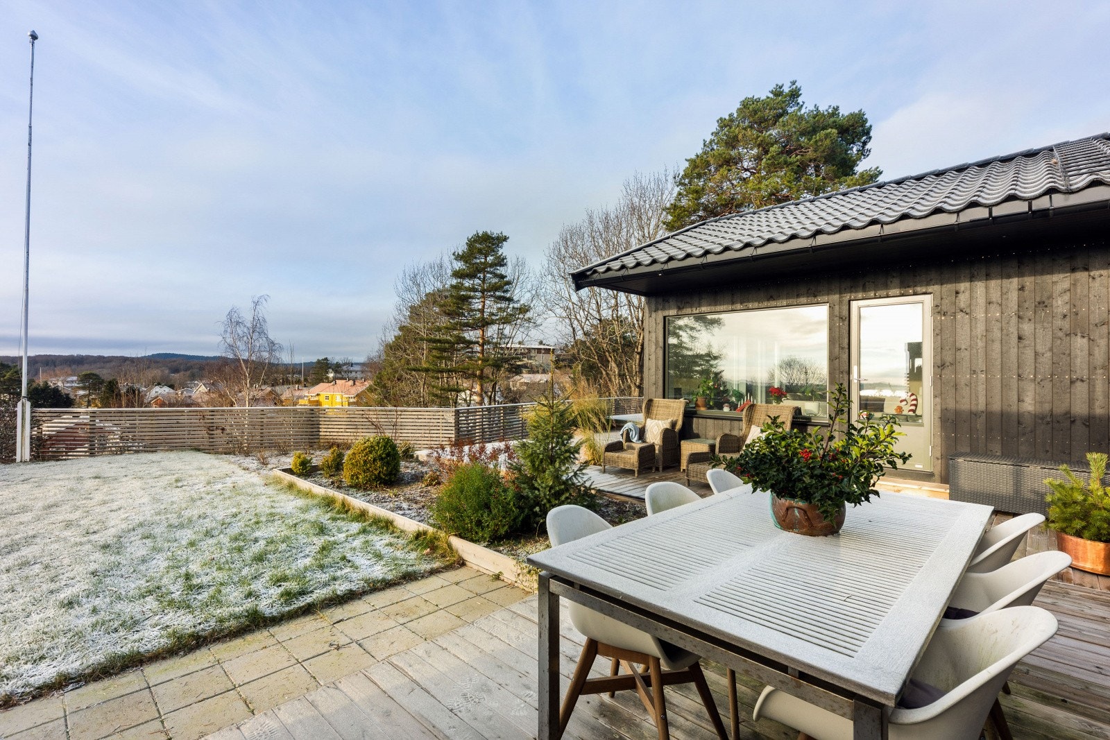 Terrassen er bygd i impregnerte materialer, har levegg og fine møbleringssoner. Det er også opparbeidet hageareal med plen, som er pent inngjerdet med rekkverk med liggende spiler. Galleribilde