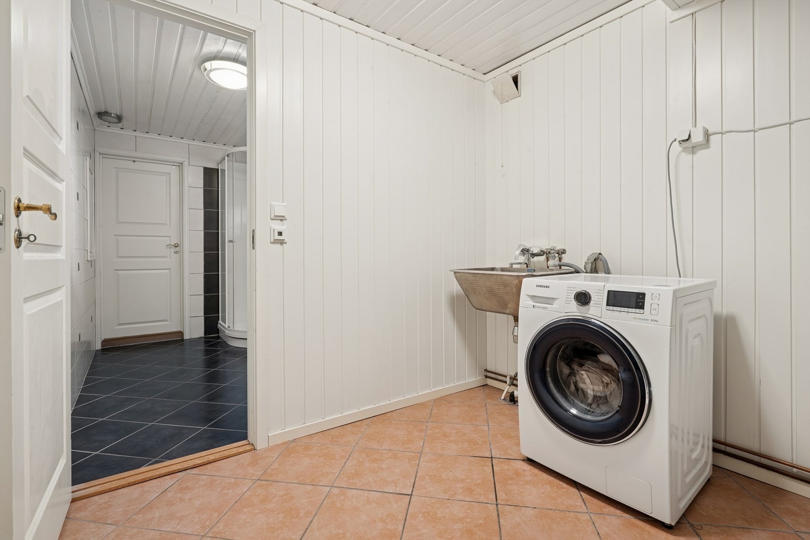 Separat vaskerom med malte panelplater på vegger og fliser på gulv. Malt panel i himling. Galleribilde