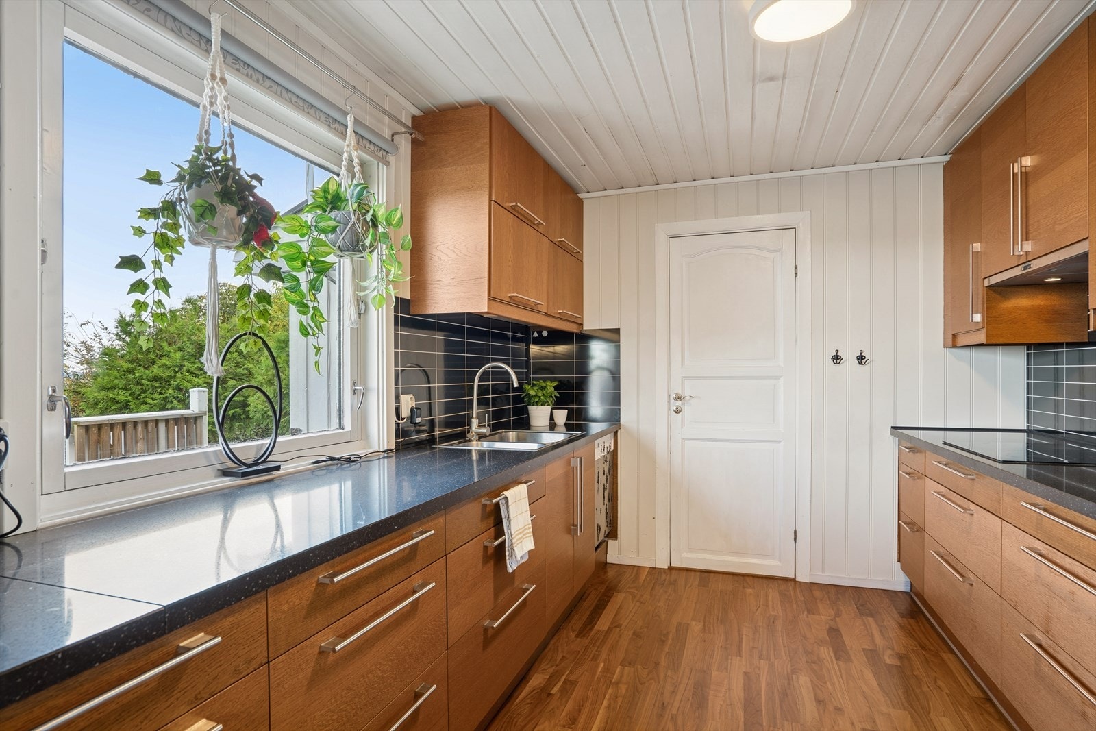 Benkeplate i granitt med nedfelt kum i rustfritt stål. Stekeovn, keramisk topp, oppvaskmaskin, mikrobølgeovn og kjøl/frys er integrert i innredningen. Galleribilde