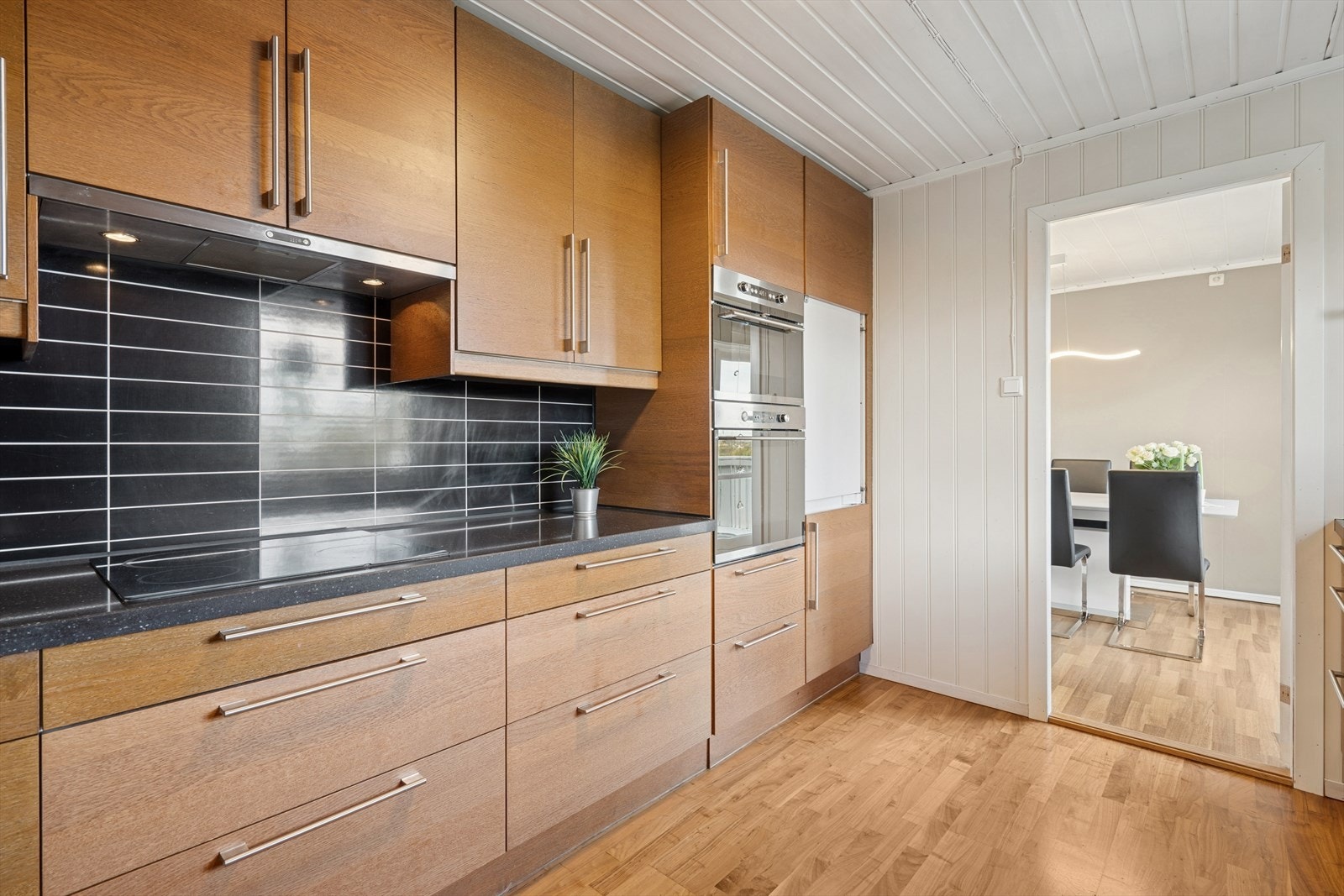 Kjøkkeninnredning fra 2009 med glatte fronter, laminatplate på vegg over benkeskap. Galleribilde