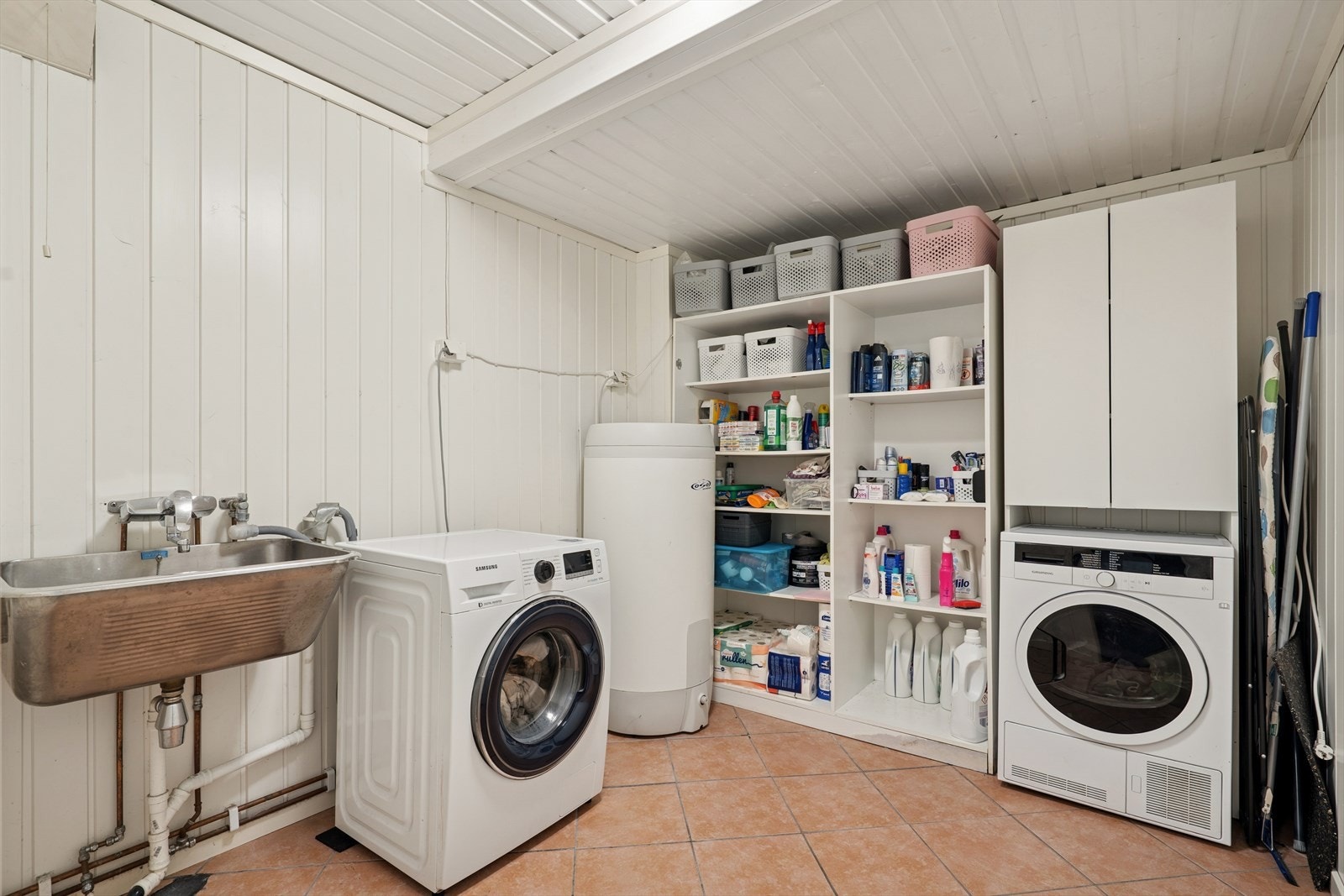 Det er utslagsvask i rustfritt stål og opplegg for vaskemaskin i vaskerommet. Galleribilde