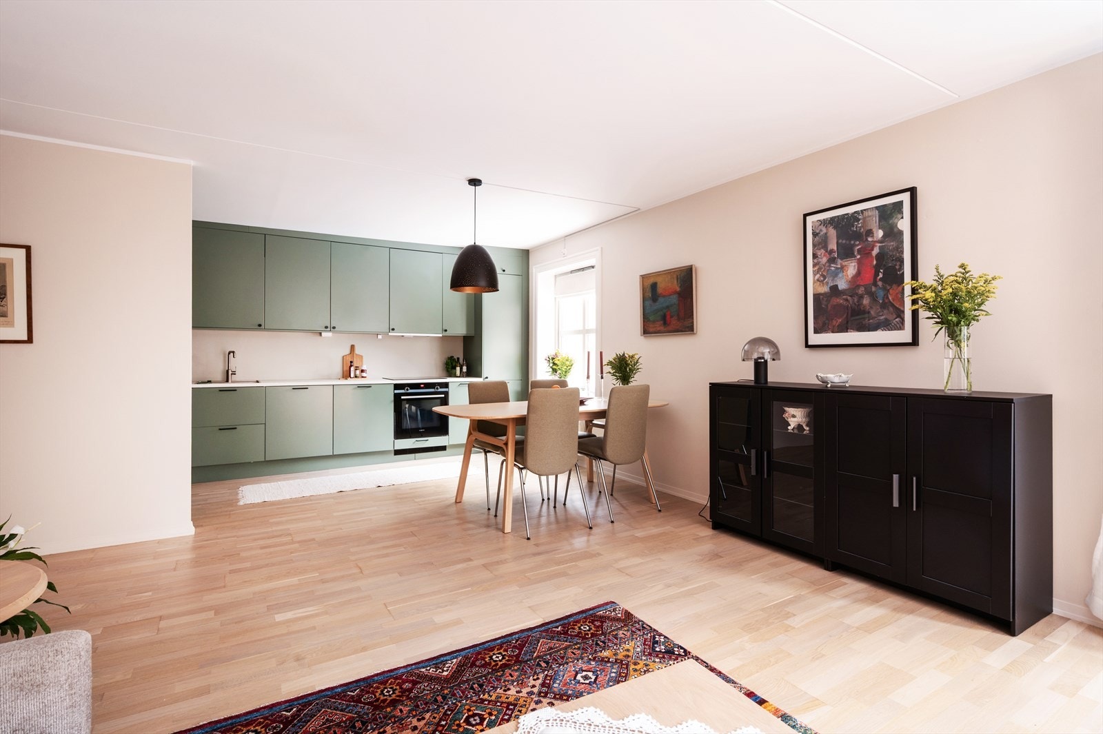 Stuen er malt i lyse og moderne fargetoner, og har en åpen løsning mot kjøkkenet som gir en luftig og sosial atmosfære. Galleribilde