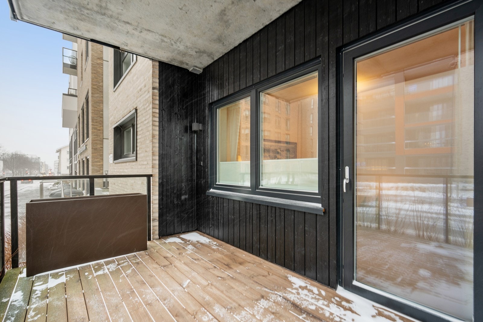 Leiligheten har utgang fra stue/kjøkken til solrik terrasse med tregulv på omtrent 9 kvm Galleribilde