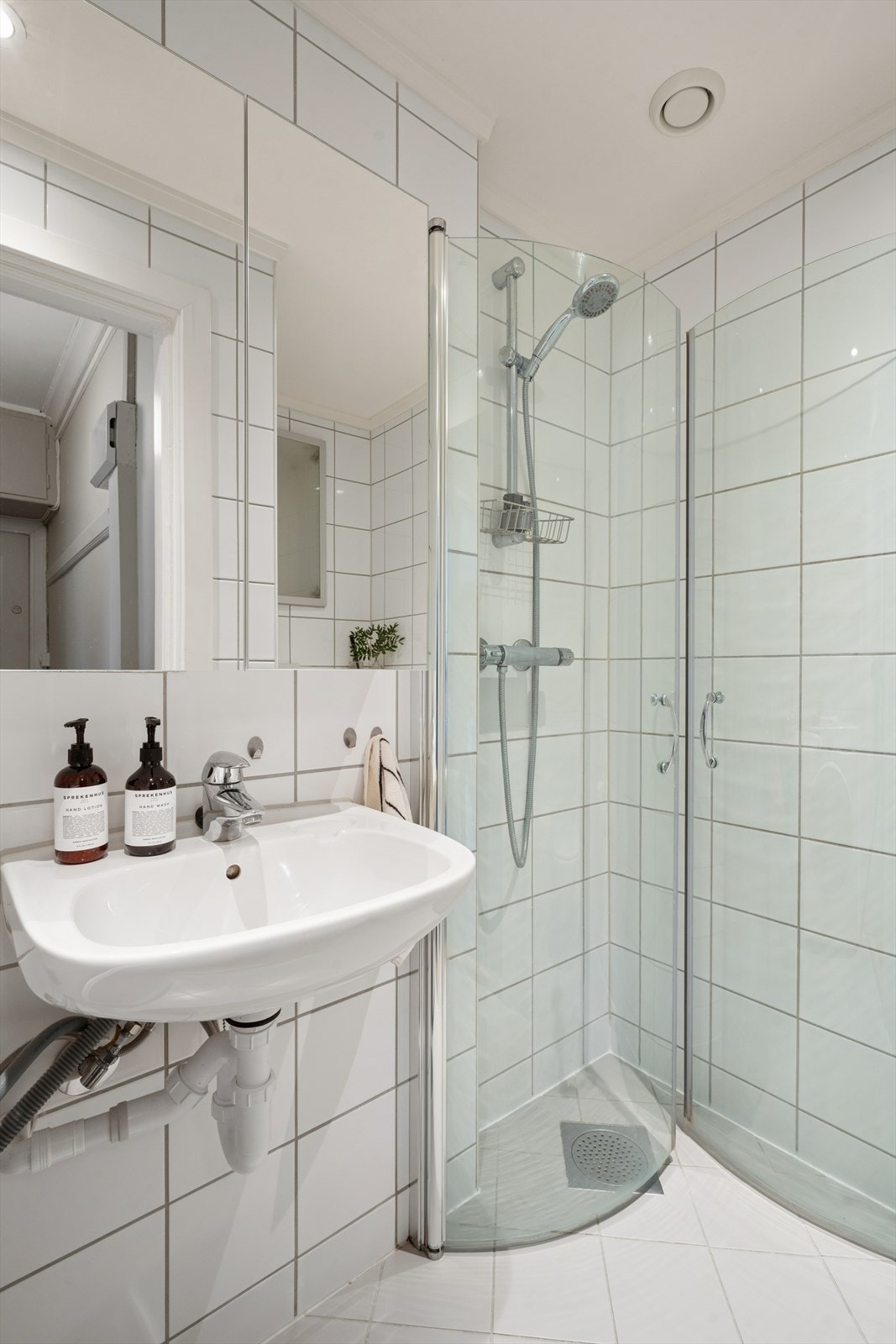 Badet er innredet med vegghengt toalett, dusjnisje med inn- og utadslående dusjdører, servant med ettgreps blandebatteri samt opplegg for vaskemaskin Galleribilde