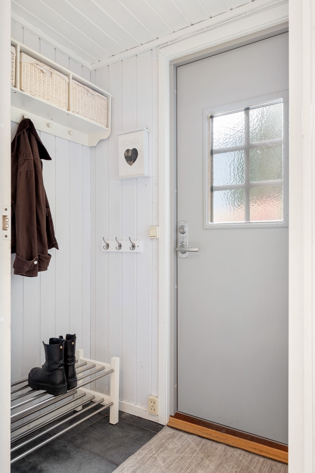 Innenfor døren møtes man av et praktisk vindfang med knagger for yttertøy og plass til å sette fra seg sko. Ved siden av vindfanget ligger en bod med gode oppbevaringsmuligheter. Galleribilde