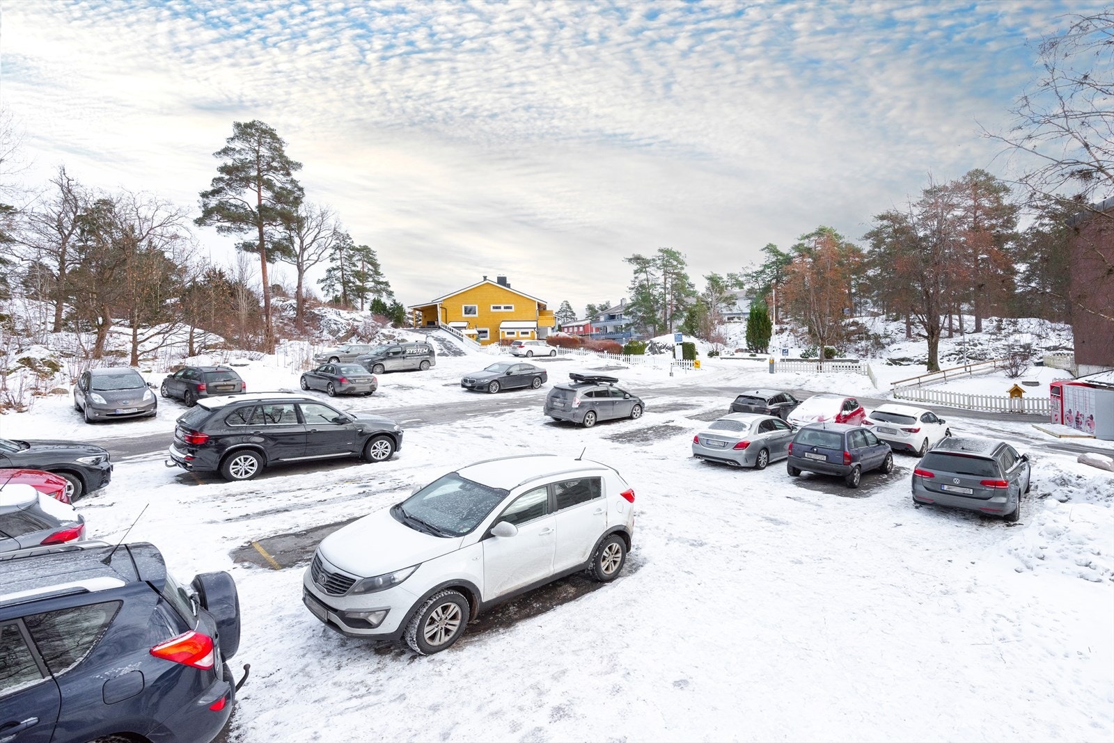 Parkeringsplassen og garasjeanlegget ligger ca. 90 meter fra rekkehuset. Galleribilde
