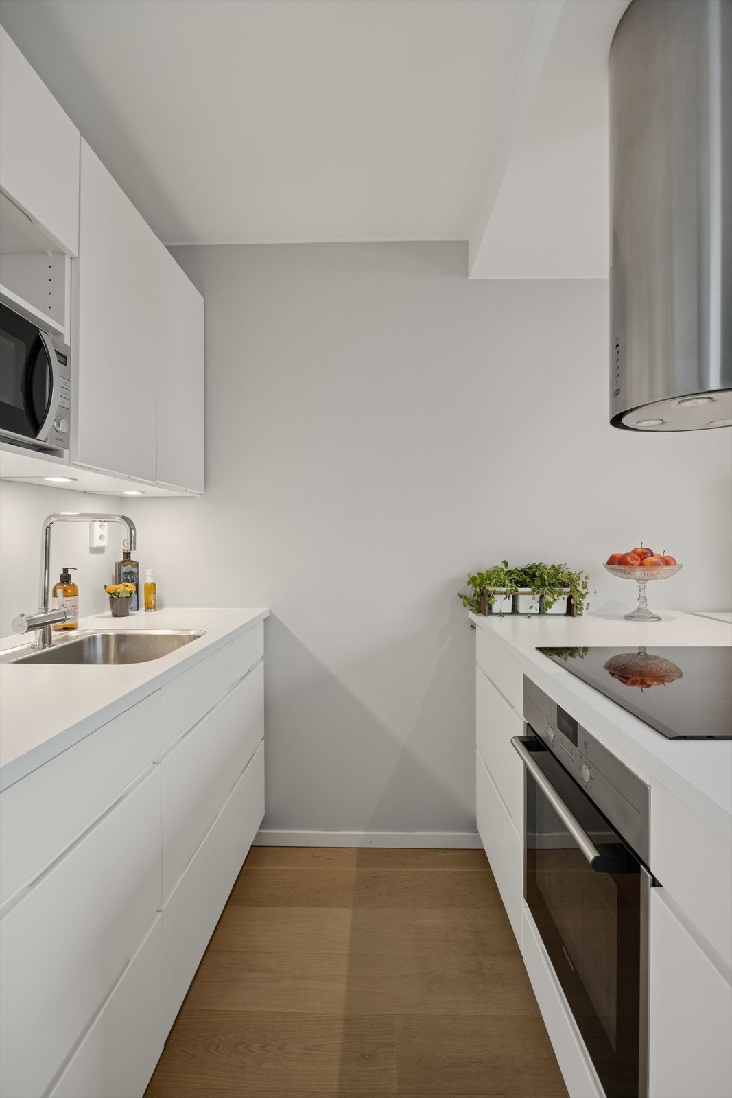 Lekker kjøkkeninnredning fra KVIK med innfelte hvitevarer bestående av stekeovn, induksjonsplatetopp, oppvaskmaskin, kjøle- og fryseskap. Galleribilde