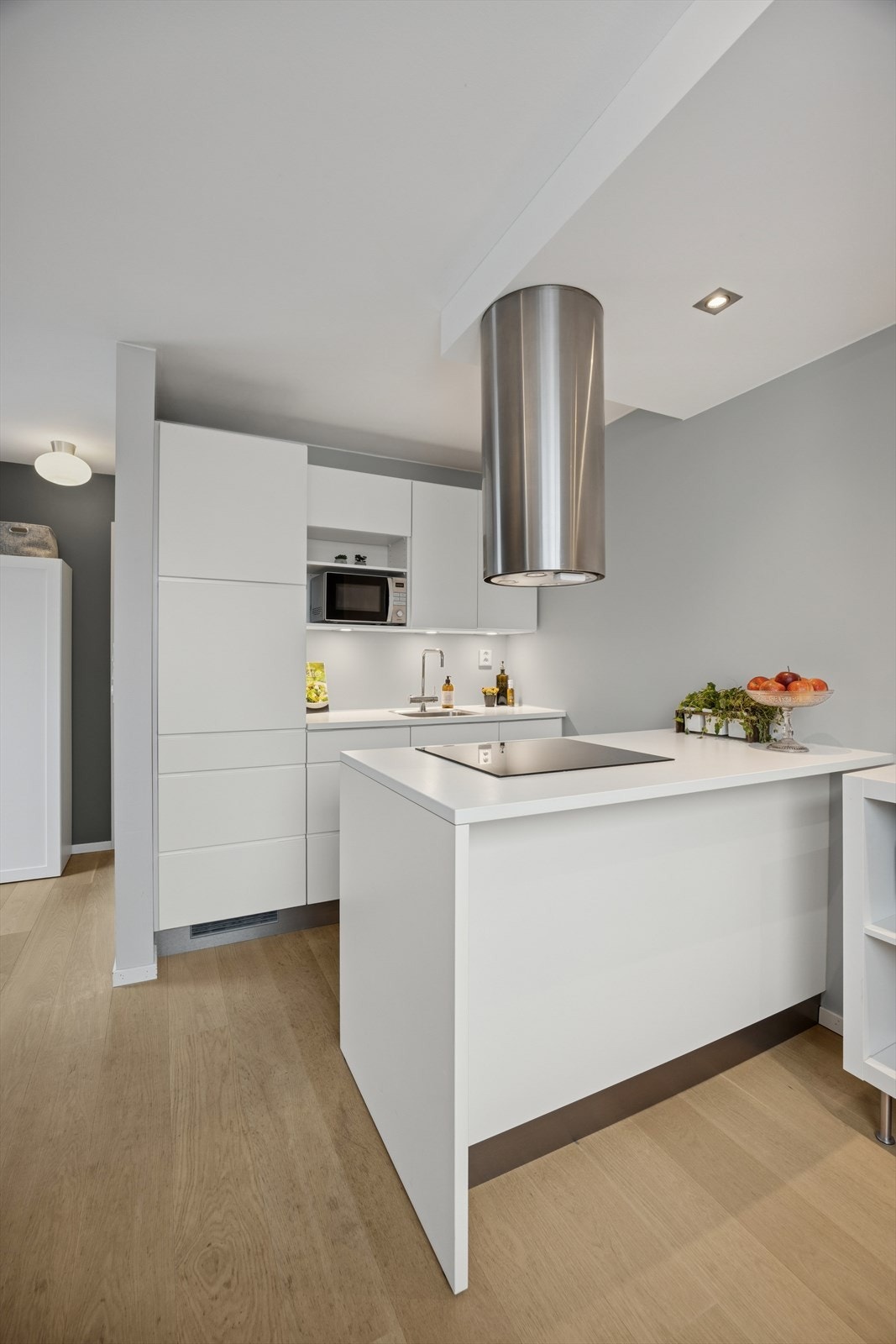 En praktisk kjøkkenøy med frittstående ventilator og innfelt induksjonsplatetopp.
Her er det også plass til et par barstoler. Galleribilde