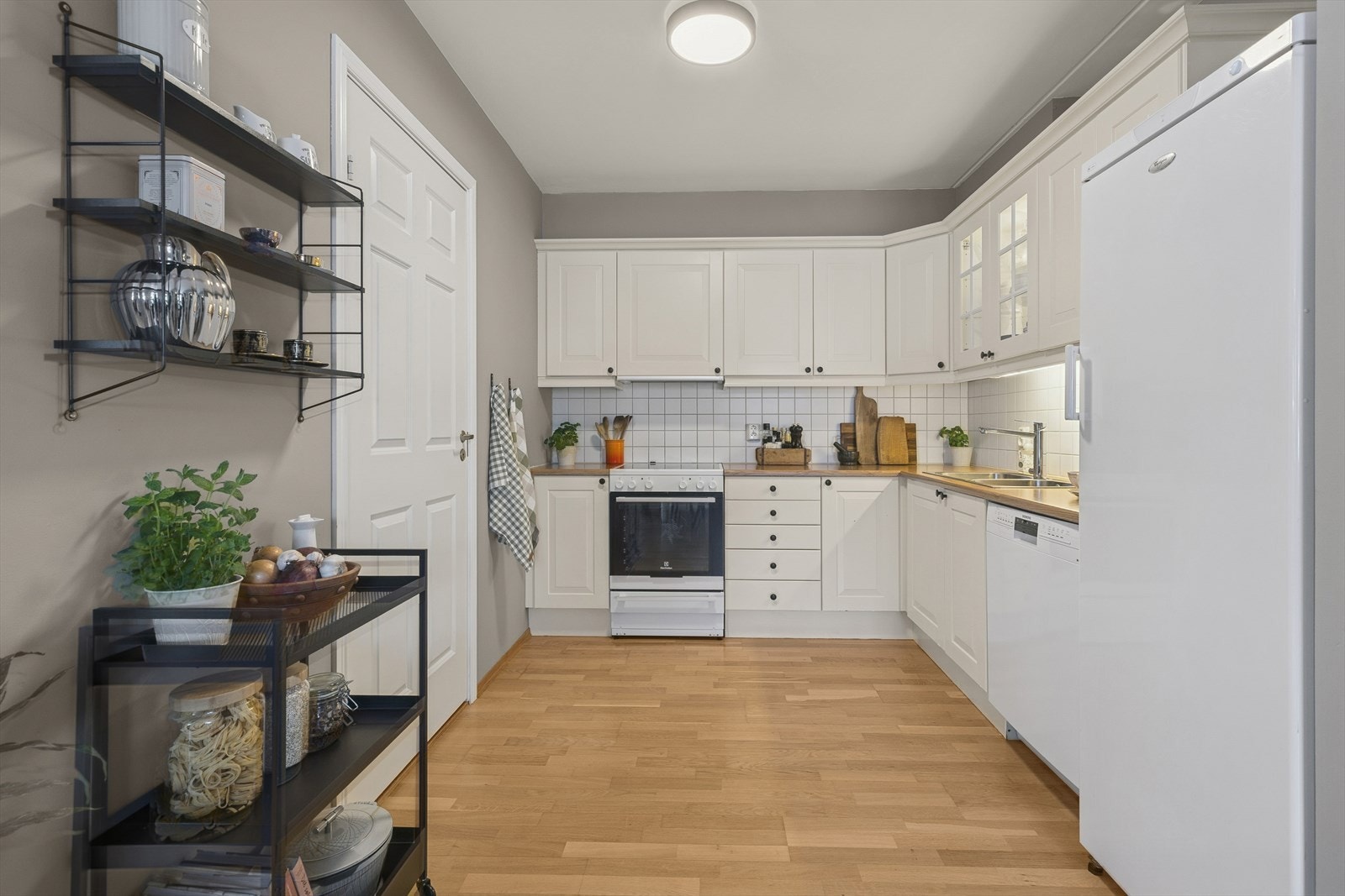 Romslig kjøkken med gode oppbevaringsmuligheter i både skuffer og skap - døren til venstre er bod Galleribilde