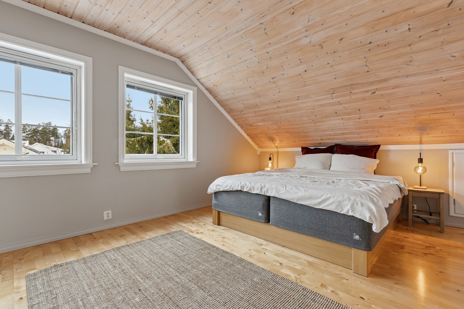 Lyst soverom i andre etasje med trepanel i taket og parkett på gulvet. Galleribilde