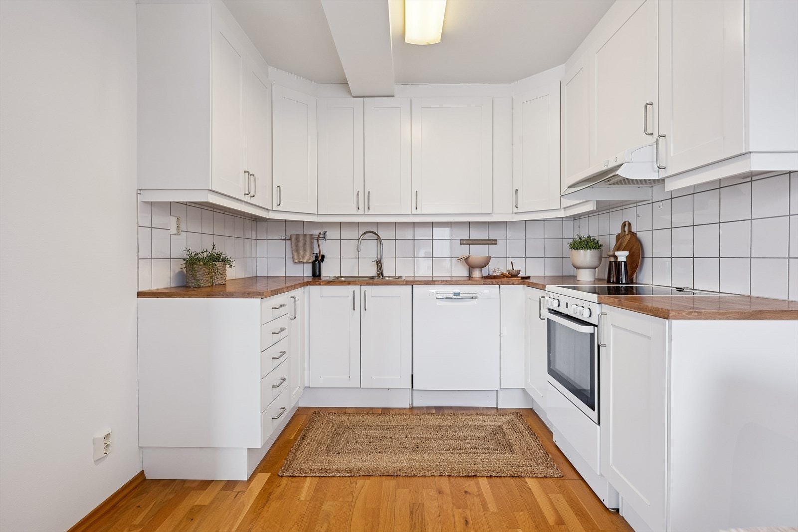 Funksjonell kjøkkeninnredning med laminert benkeplate og godt med skap- og benkeplass. Galleribilde