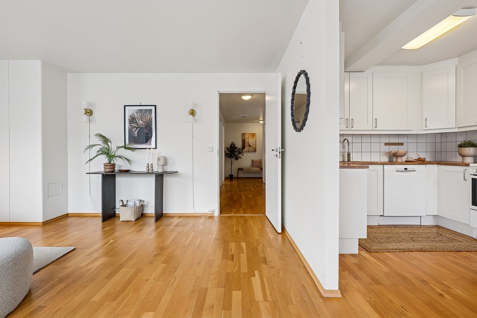 Fra entréen åpner leiligheten seg med gjennomgående parkett og siktlinjer mot oppholdsrommene. Galleribilde