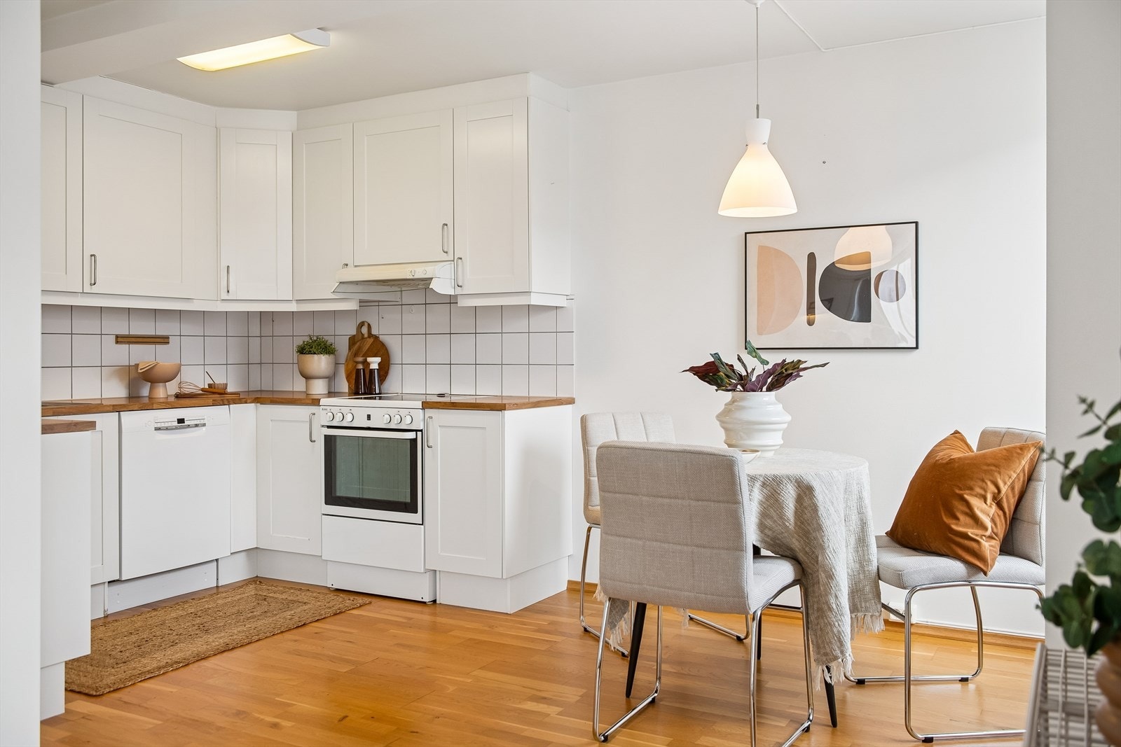 Kjøkkenet har fliser over benken og en kjøkkenventilator montert over komfyrplassen. Galleribilde