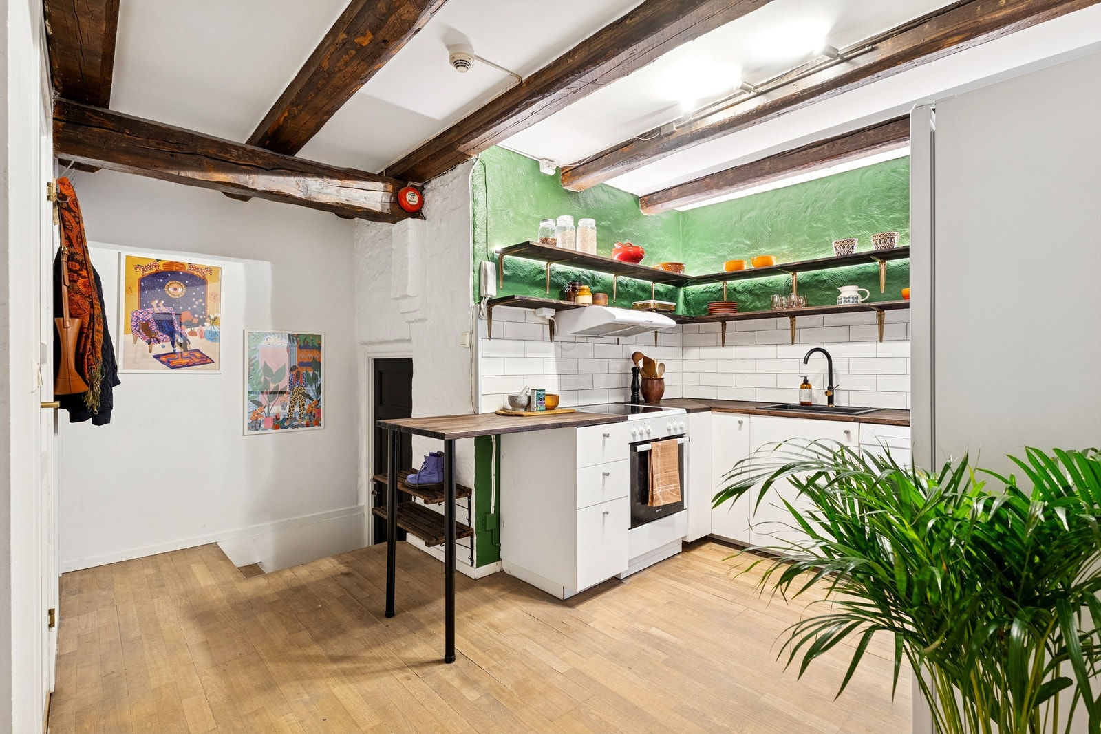 Kjøkkenet møter deg med et tydelig førsteinntrykk av leilighetens unike stil, der de markante tredragerne setter tonen. Galleribilde