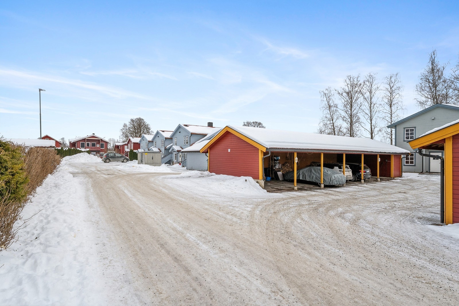 Til boligen følger biloppstillingsplass i felles carportrekke. (Det er ikke de røde carportene som hører til denne boligen) Galleribilde