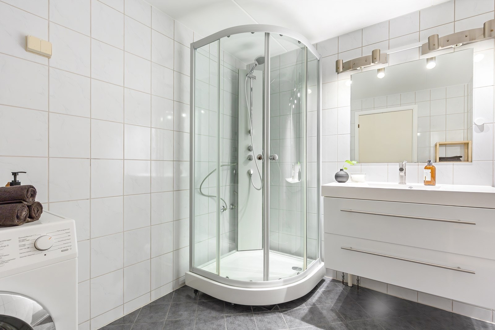 Badet er innredet med dusjkabinett og servant med ettgreps blandebatteri i innredning. Galleribilde