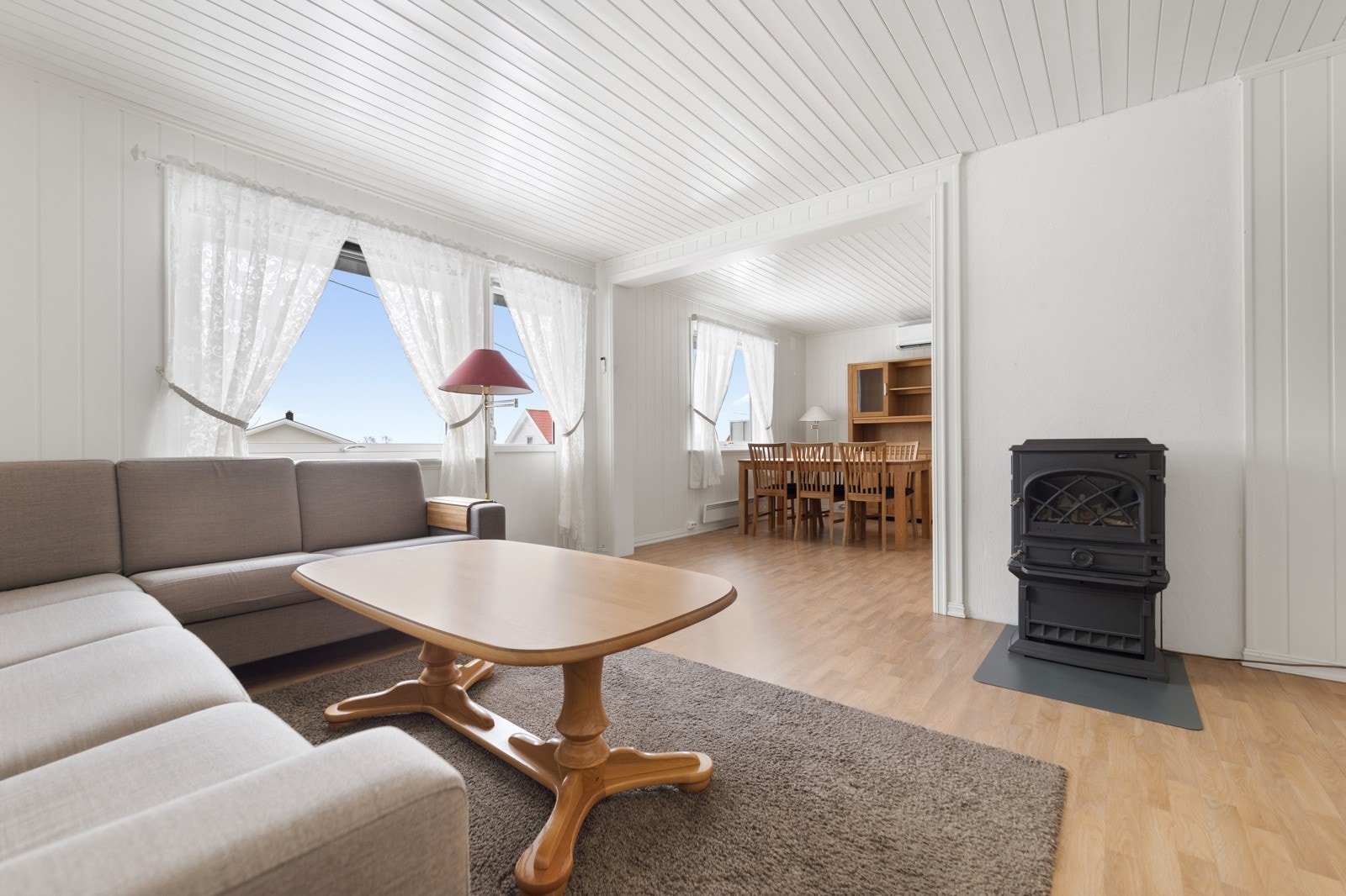 Lys, koselig stue med plass til sofakrok og ønsket møblement. Vedovnen gir lun stemning på kjølige dager. Galleribilde