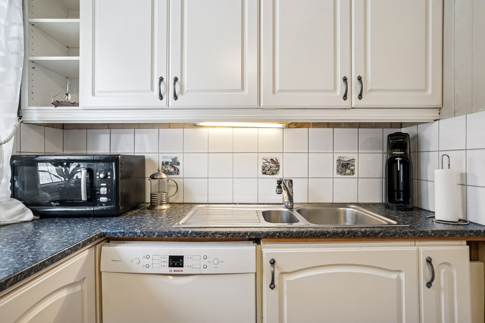 Benkeplaten i laminat har oppvaskkum i metall og opplegg for oppvaskmaskin. Galleribilde