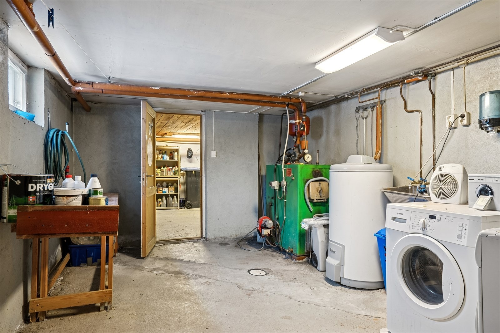 Praktisk vaskerom i kjeller med opplegg for vaskemaskin og plassering av varmtvannsbereder. Galleribilde