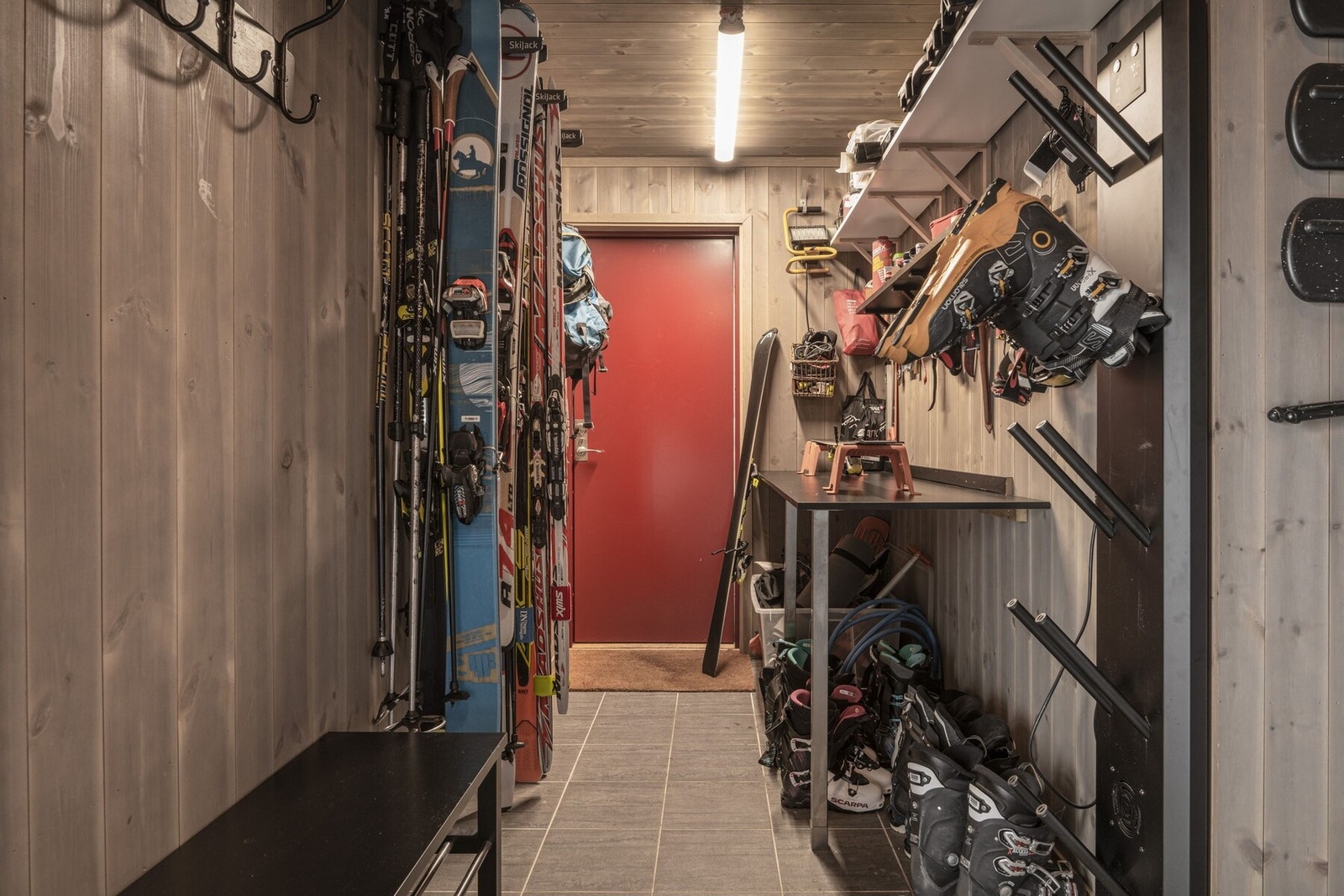 Romslig vaskerom/sportsbod med både utvendig og innvendig praktisk adkomst. Her har man varmestativ til slalomstøvler og rikelig med plass til oppbevaring av ski og utstyr samt opplegg for både vaskemaskin og tørketrommel. Galleribilde