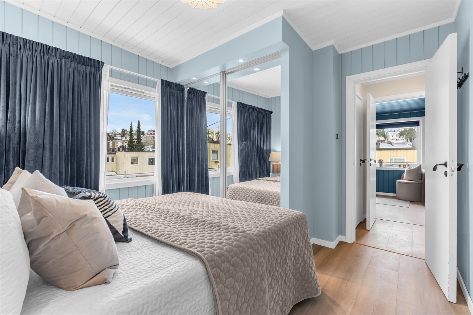 Klær kan pent ryddes bort i et romslig plassbygget garderobeskap med speilfronter. Galleribilde