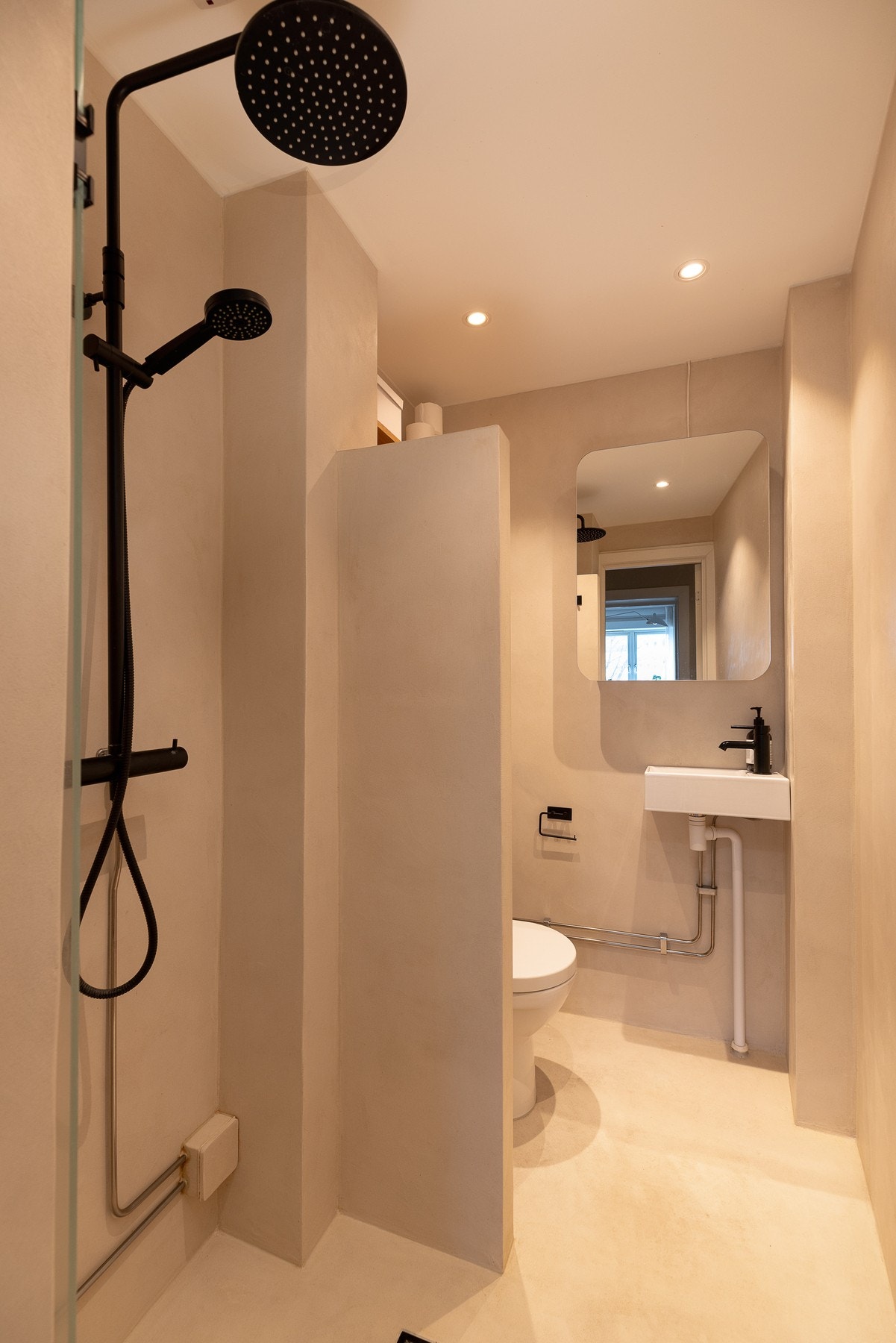 Delikat baderom som er overflateoppusset i 2022 med mikrosement, nytt tak med downlights og nytt sanitærutstyr. Galleribilde