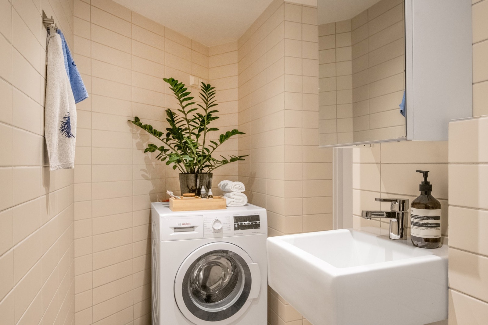 Baderomsinnredning med heldekkende servant, speilskap med hyller og belysning over. Galleribilde