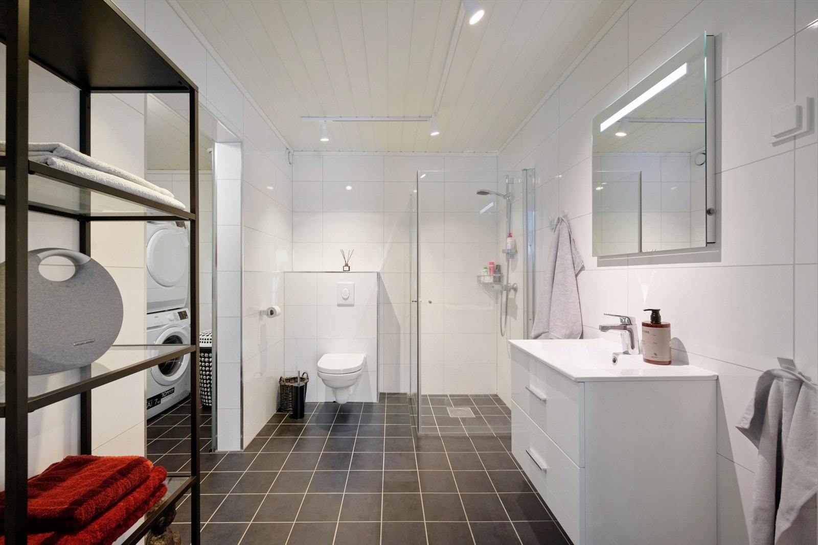 Delikat baderom med servantskap, vegghengt toalett og dusjnisje. Galleribilde