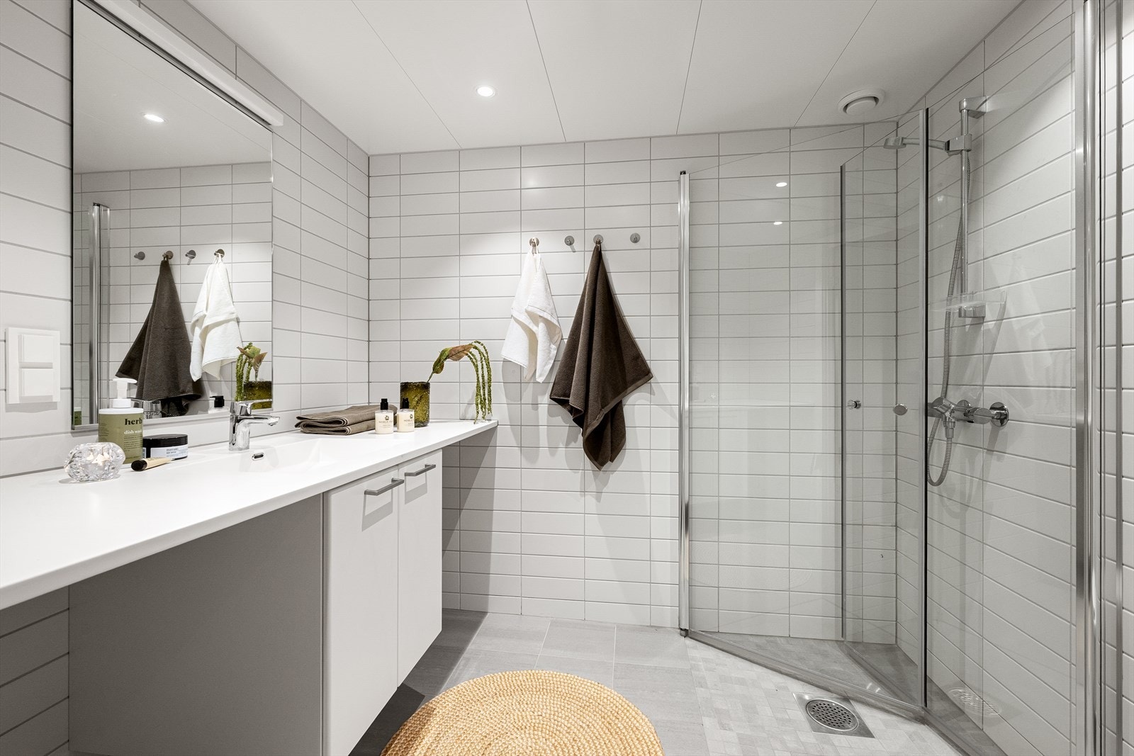 Lyst flislagt baderom med vannbåren gulvvarme og downlights i himling Galleribilde