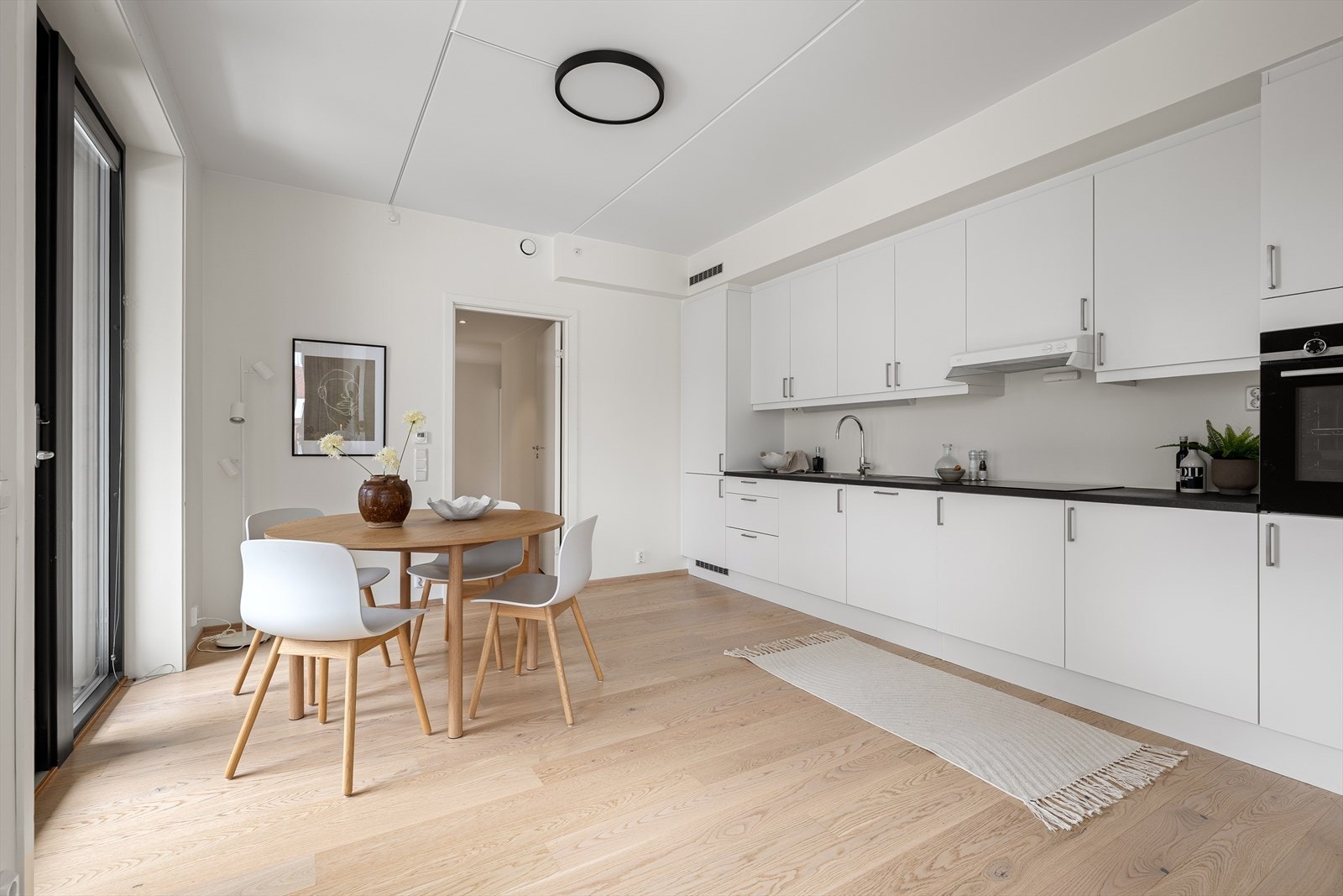 Leiligheten har lekker en-stavs parkett på gulv og lysmalte vegger Galleribilde