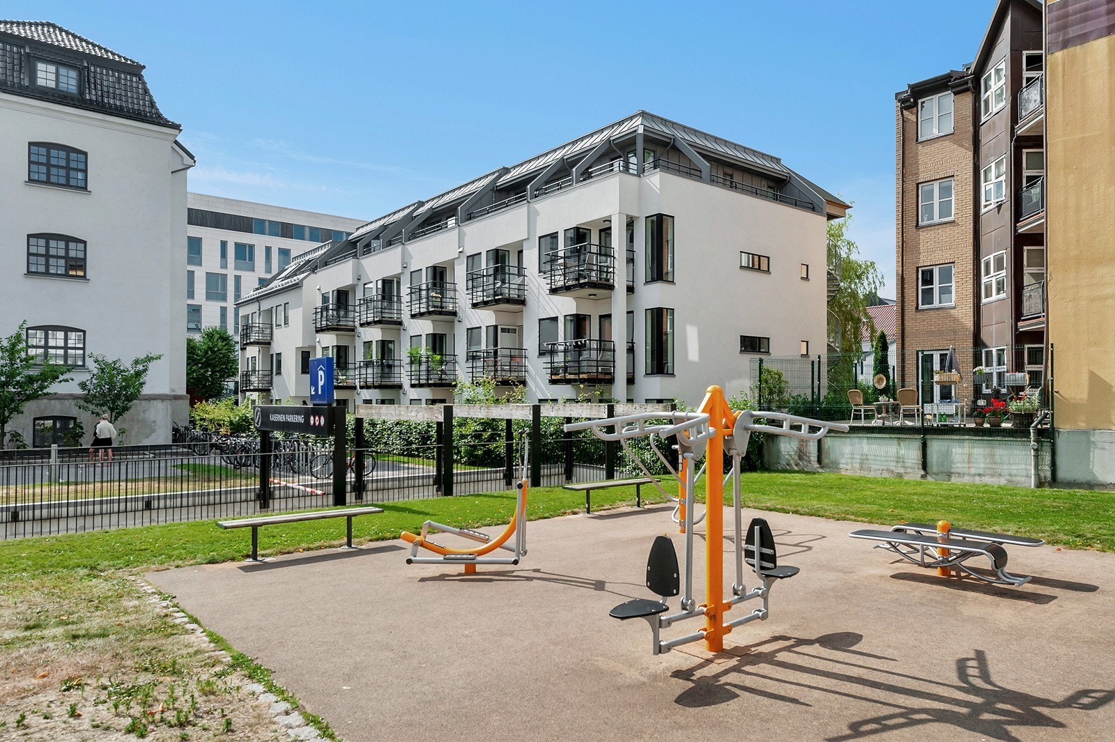 Pent opparbeidet uteområde med gressplen, benker og flott beplantning Galleribilde