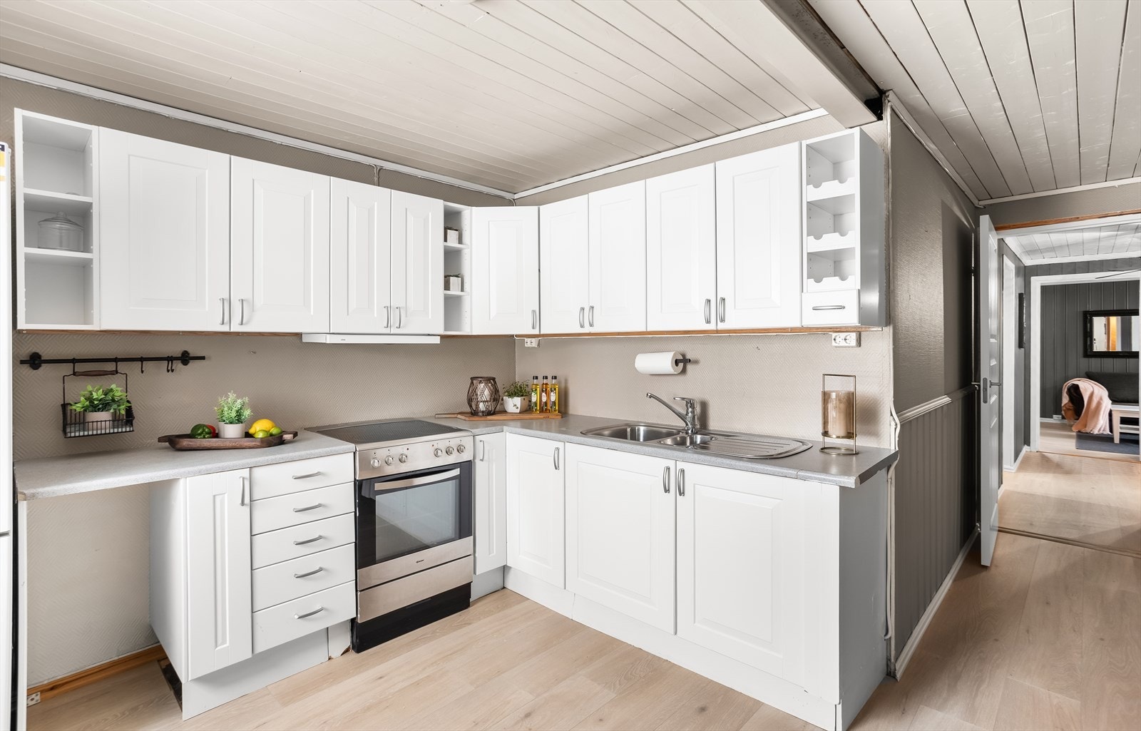 Kjøkkenet i kjelleren har en funksjonell innredning med hvitmalte, profilerte fronter. Galleribilde