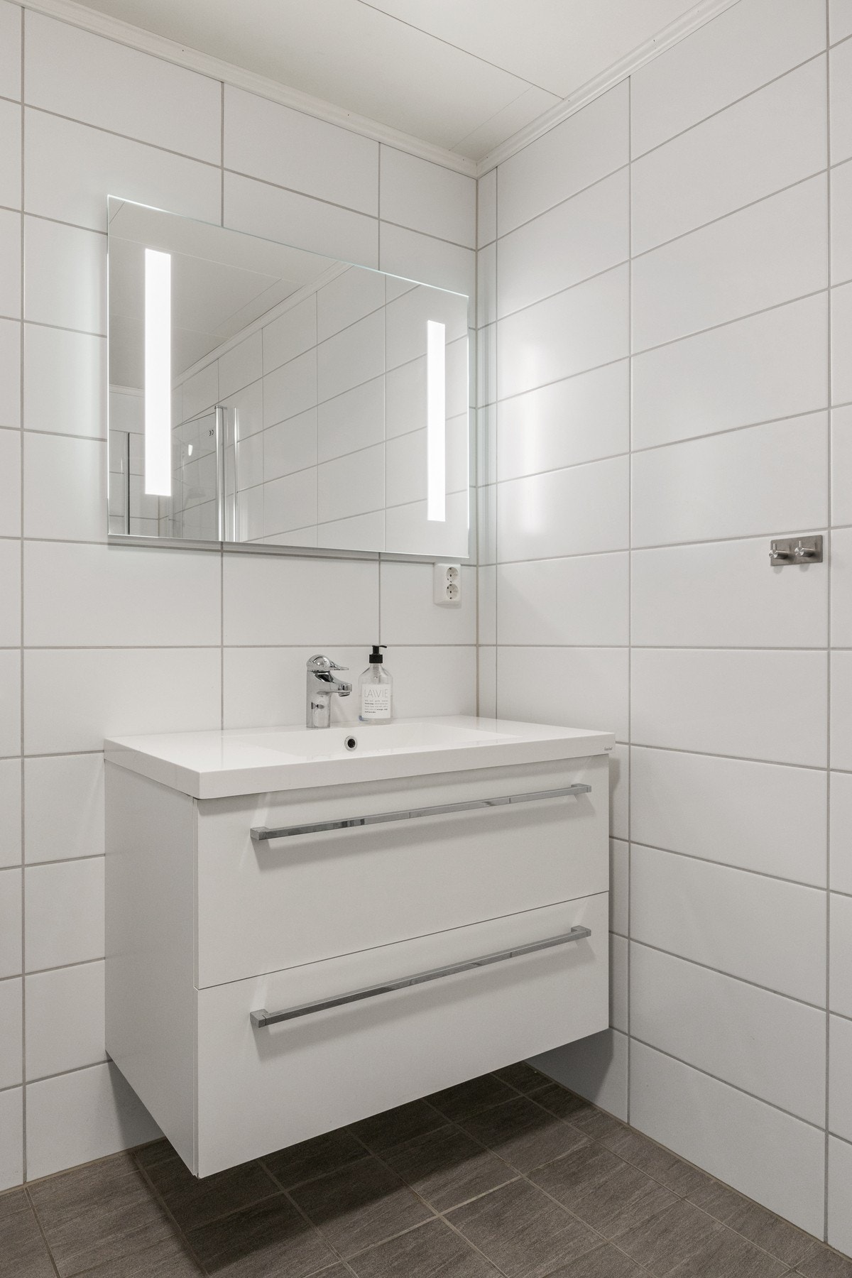 Badet er utstyrt med servantskap, toalett, innfellbare dusjdører og opplegg for vaskemaskin Galleribilde