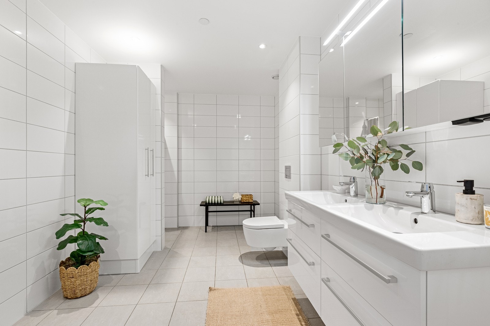 Romslig og lekkert bad med to servanter, dusjhjørne og praktisk opplegg for vaskemaskin. Galleribilde