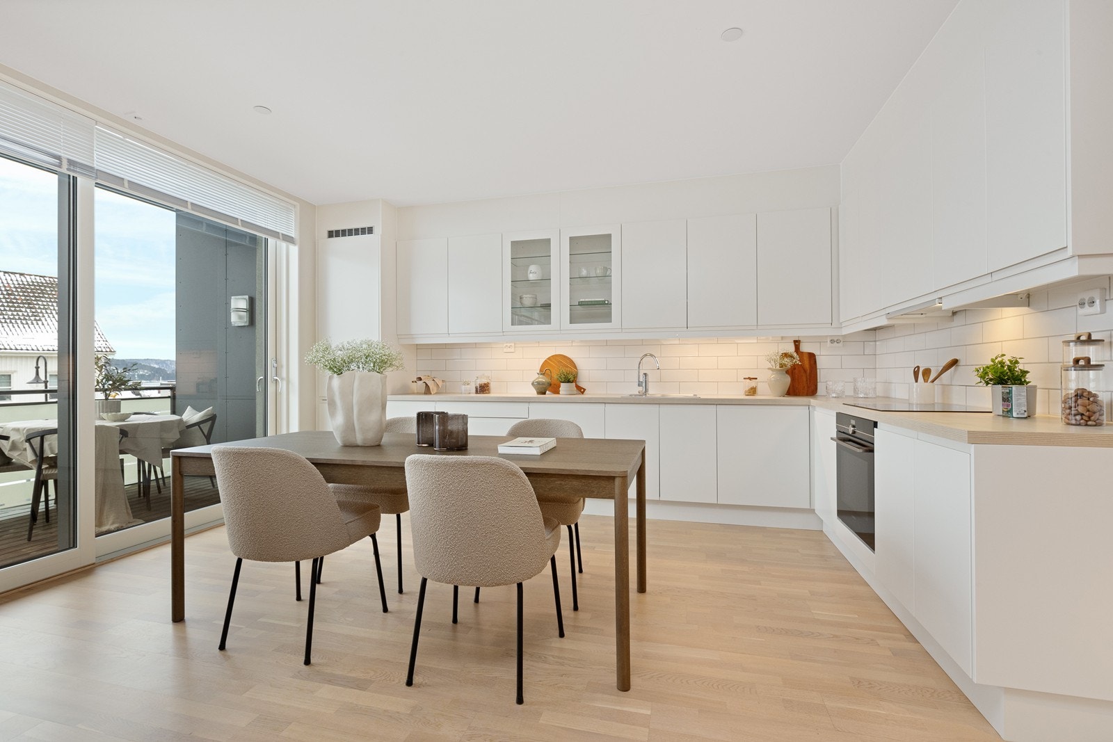 Lyst og moderne kjøkken med integrerte hvitevarer og god plass til spisebord. Galleribilde