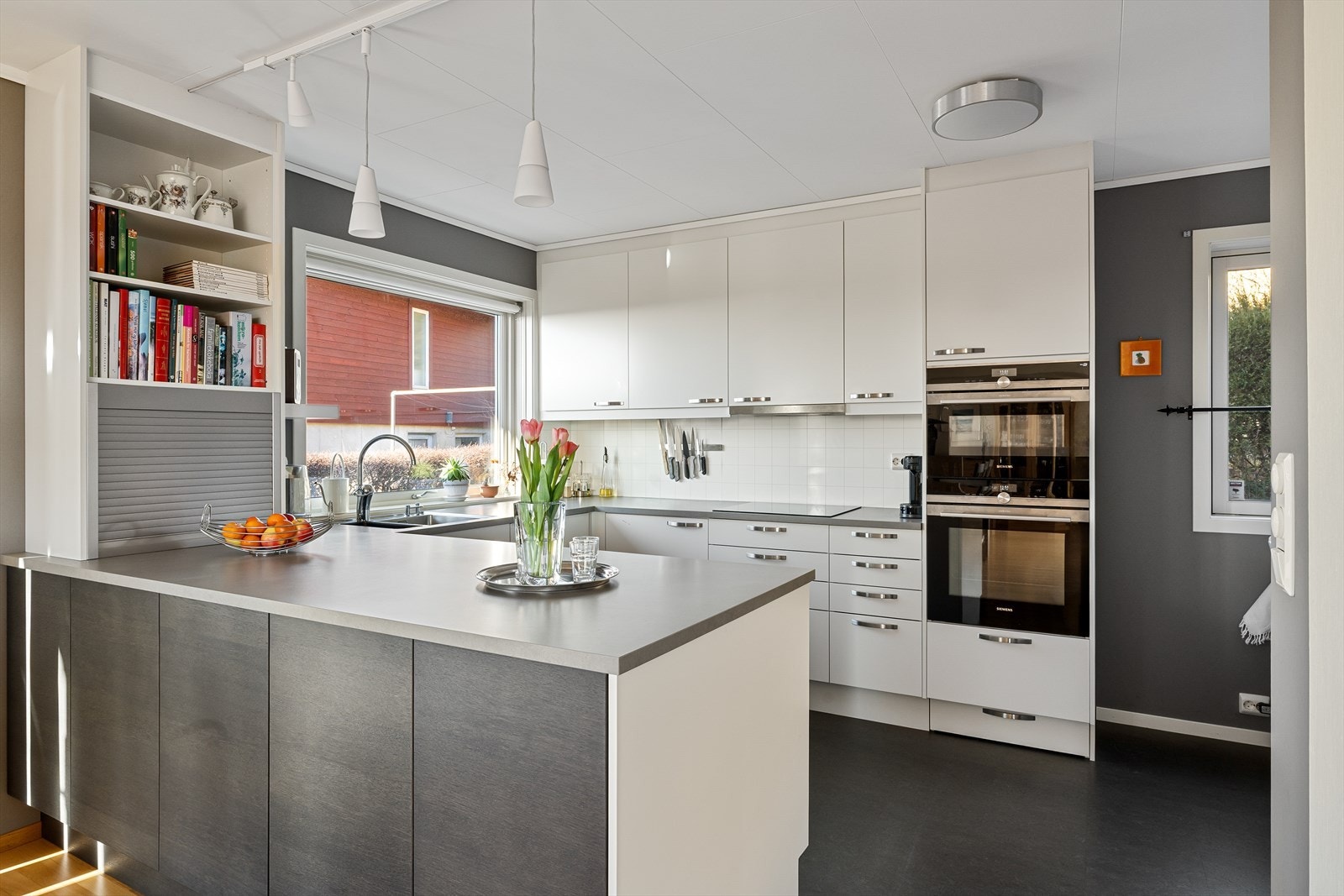 Flott kjøkken med pen kjøkkeninnredning i hvit utførelse og integrerte hvitevarer. Galleribilde