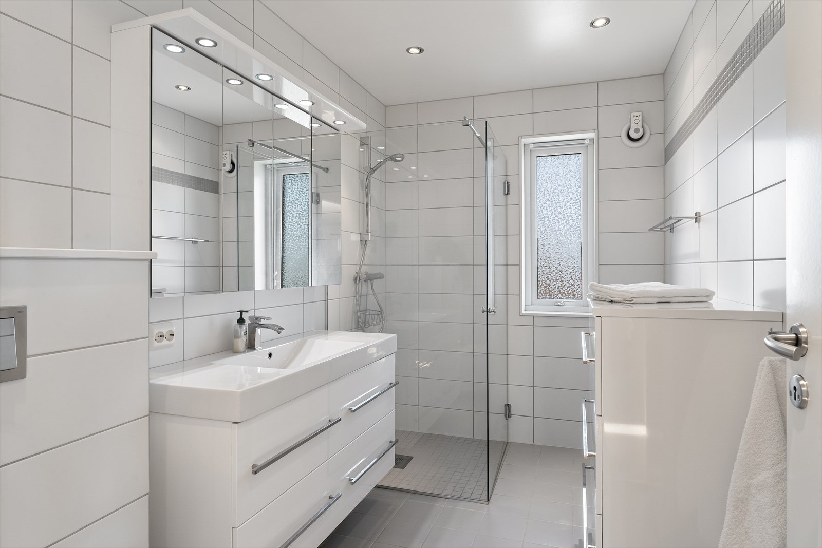 Badet fremstår som arealeffektivt med pen baderomsinnredning i hvit utførelse. Galleribilde