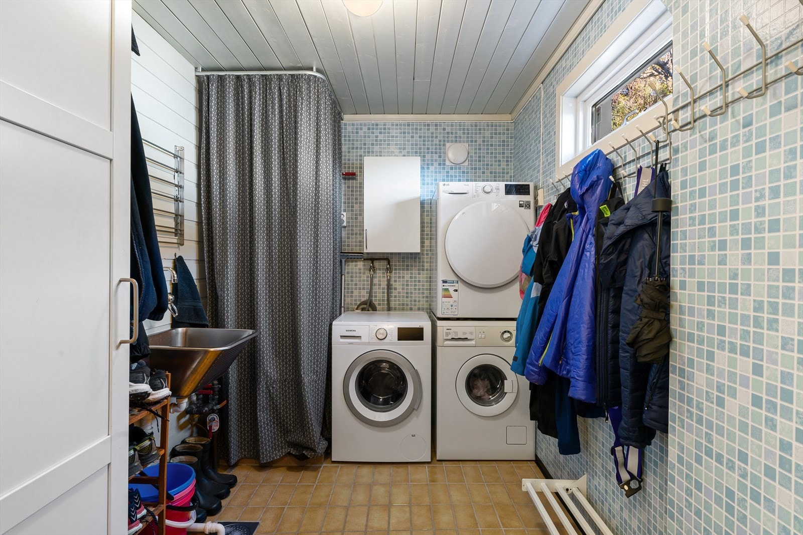 Egen bi-inngang til boligens vaskerom med opplegg for både vaskemaskin og tørketrommel. Har man barn er dette også en perfekt plass til å ta av våte klær eller når barna kommer hjem fra f.eks. fotballtrening eller sykling. Galleribilde