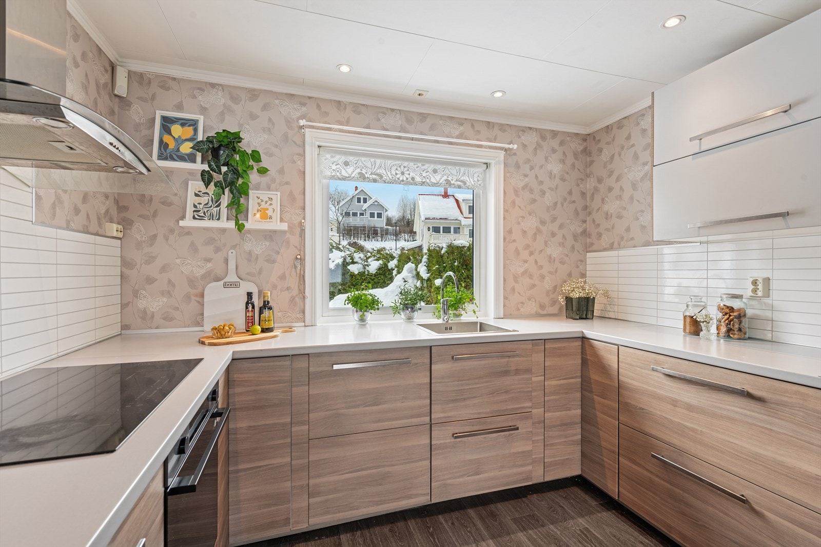 Innredet med glatte fronter, laminat benkeplate og integrert platetopp, stekeovn og oppvaskmaskin. Galleribilde