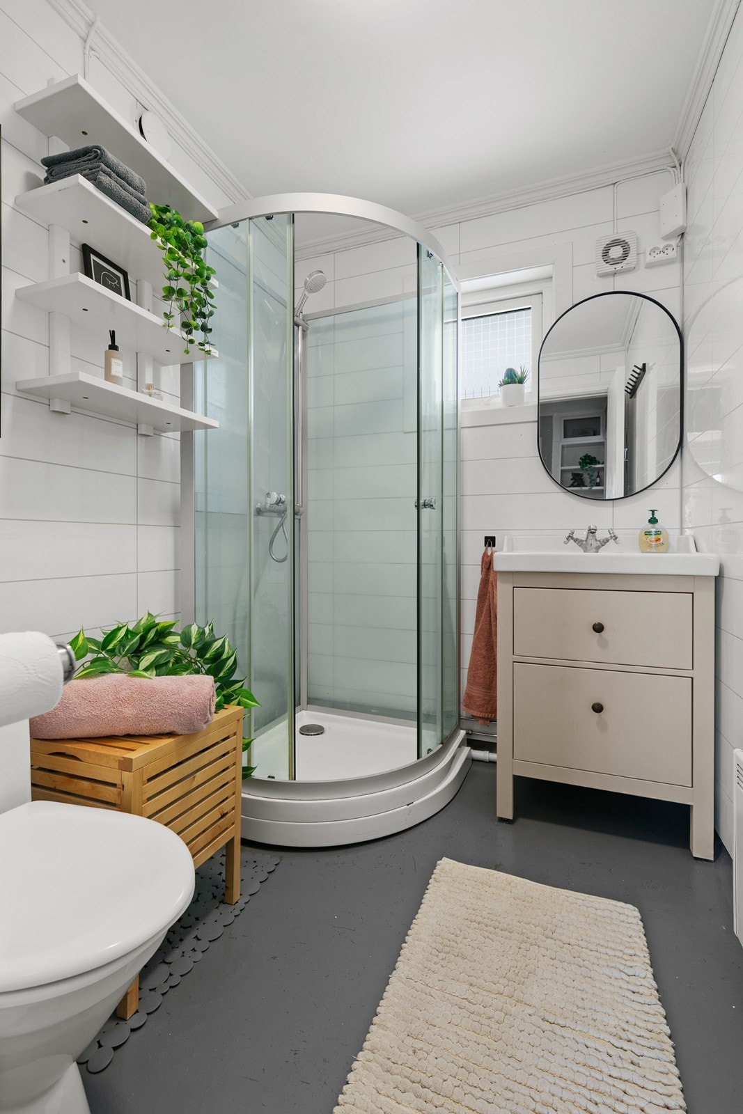 Badet inneholder dusjkabinett, servant med skuffer og wc. Galleribilde